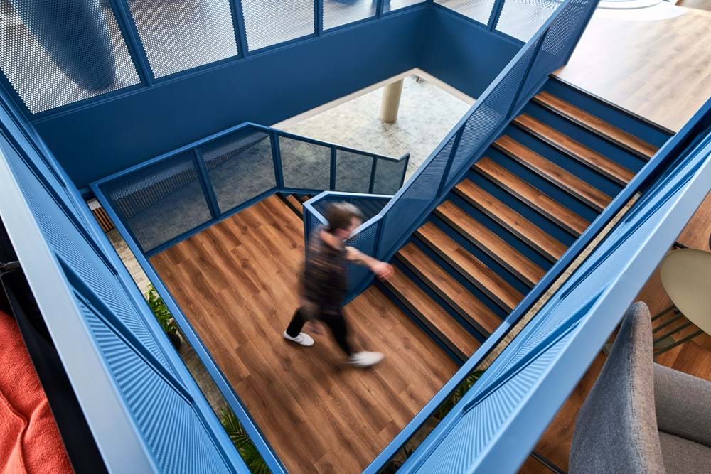 A person walking up a blue feature staircase