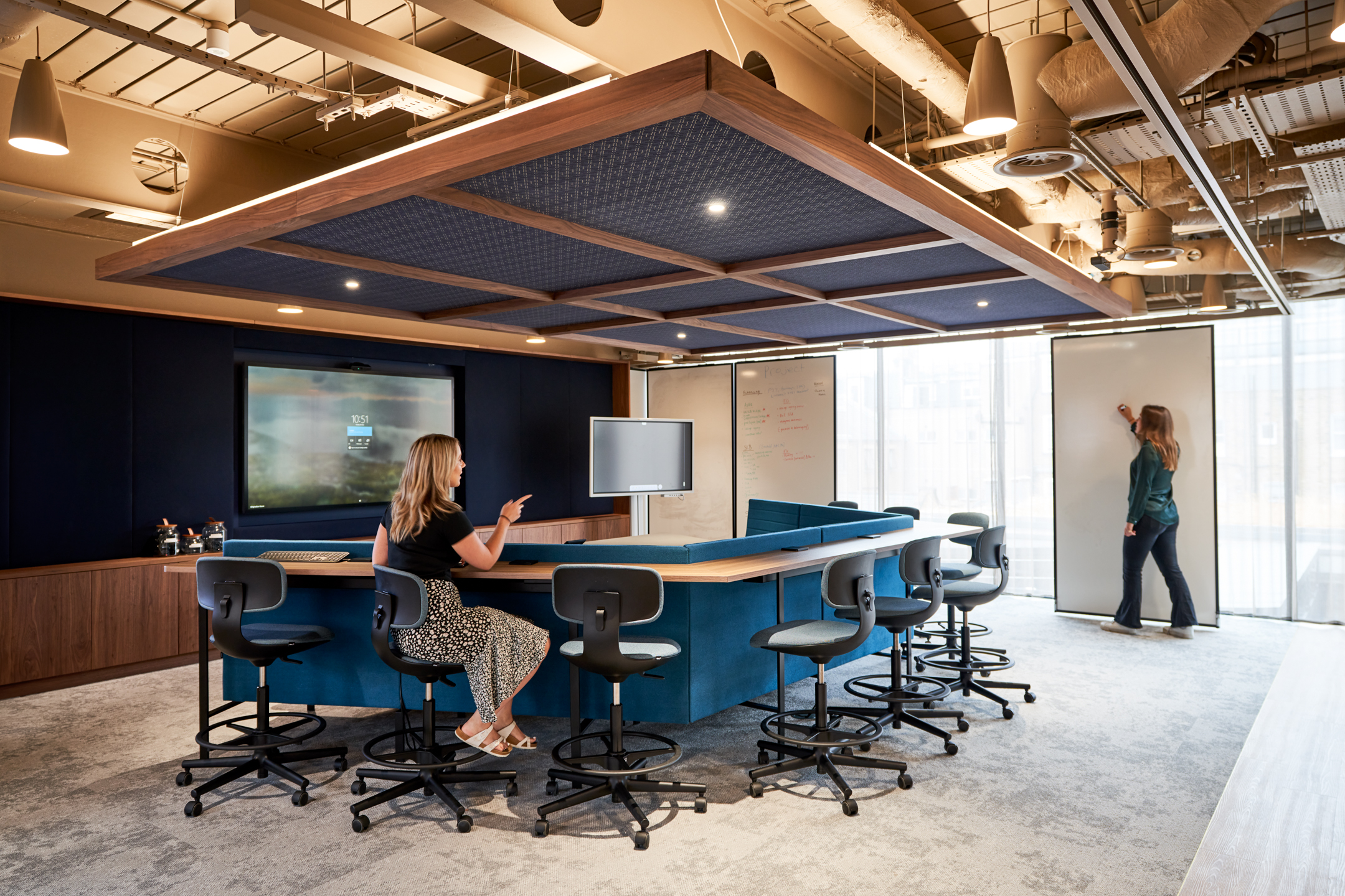 Improving Your Workspace with Data and Analytics featuring TDR's large meeting room with a large screen, a presentation style layout and large whiteboards.