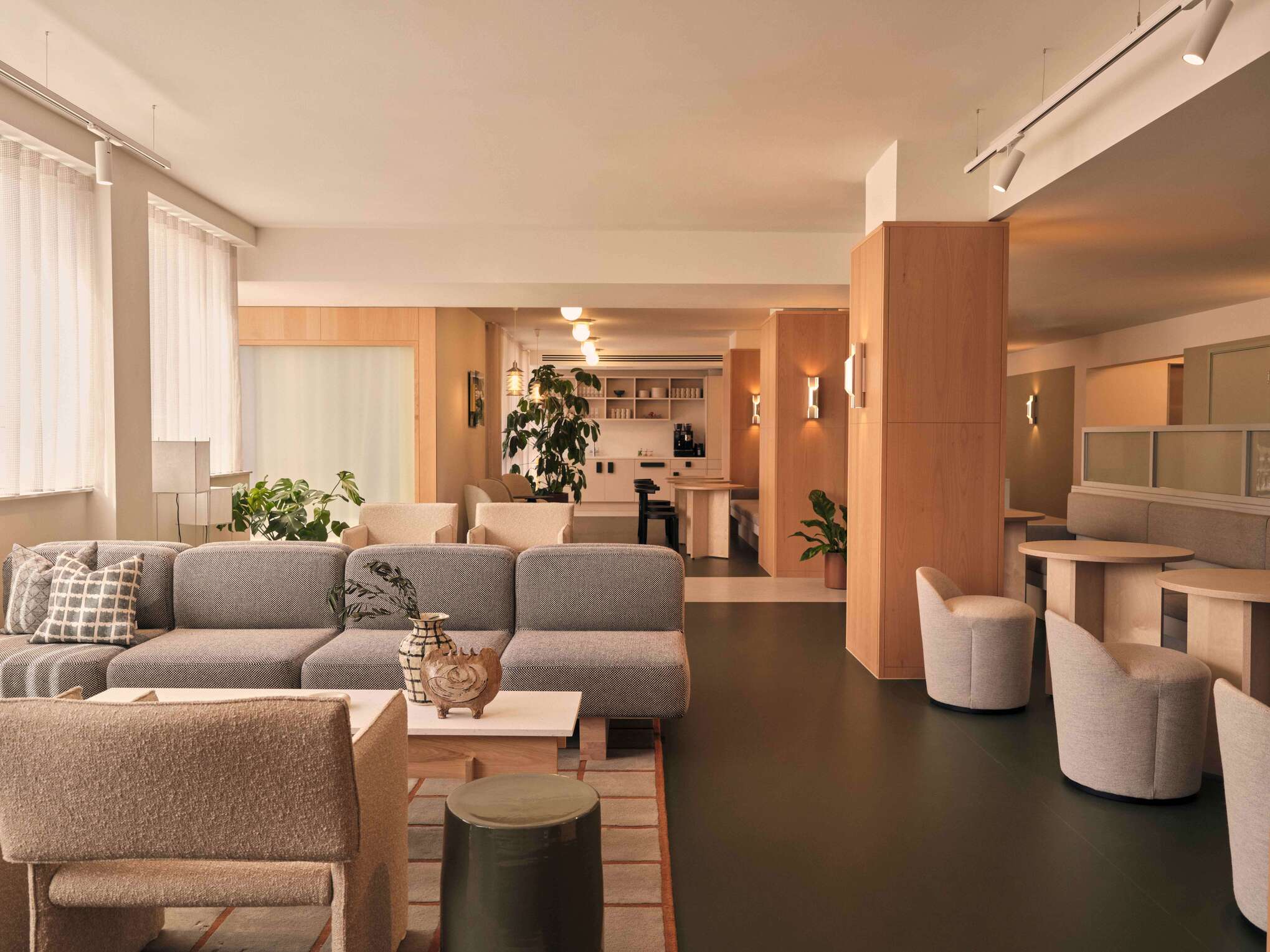 A large lounge area with modular seating and a variety of textures and tones. The space is versatile, designed to accommodate group activities or quiet reflection, enhanced by contemporary decor and strategic lighting.