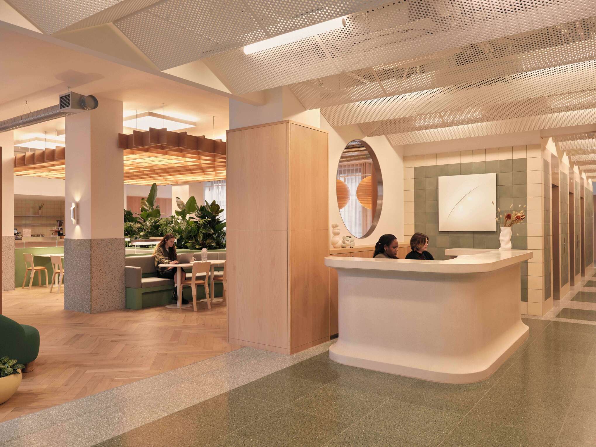 A large, multifunctional space serving as a reception and dining area, featuring modern furniture in muted greens and beiges. The design includes unique lighting fixtures and expansive seating areas, suitable for socializing or working.