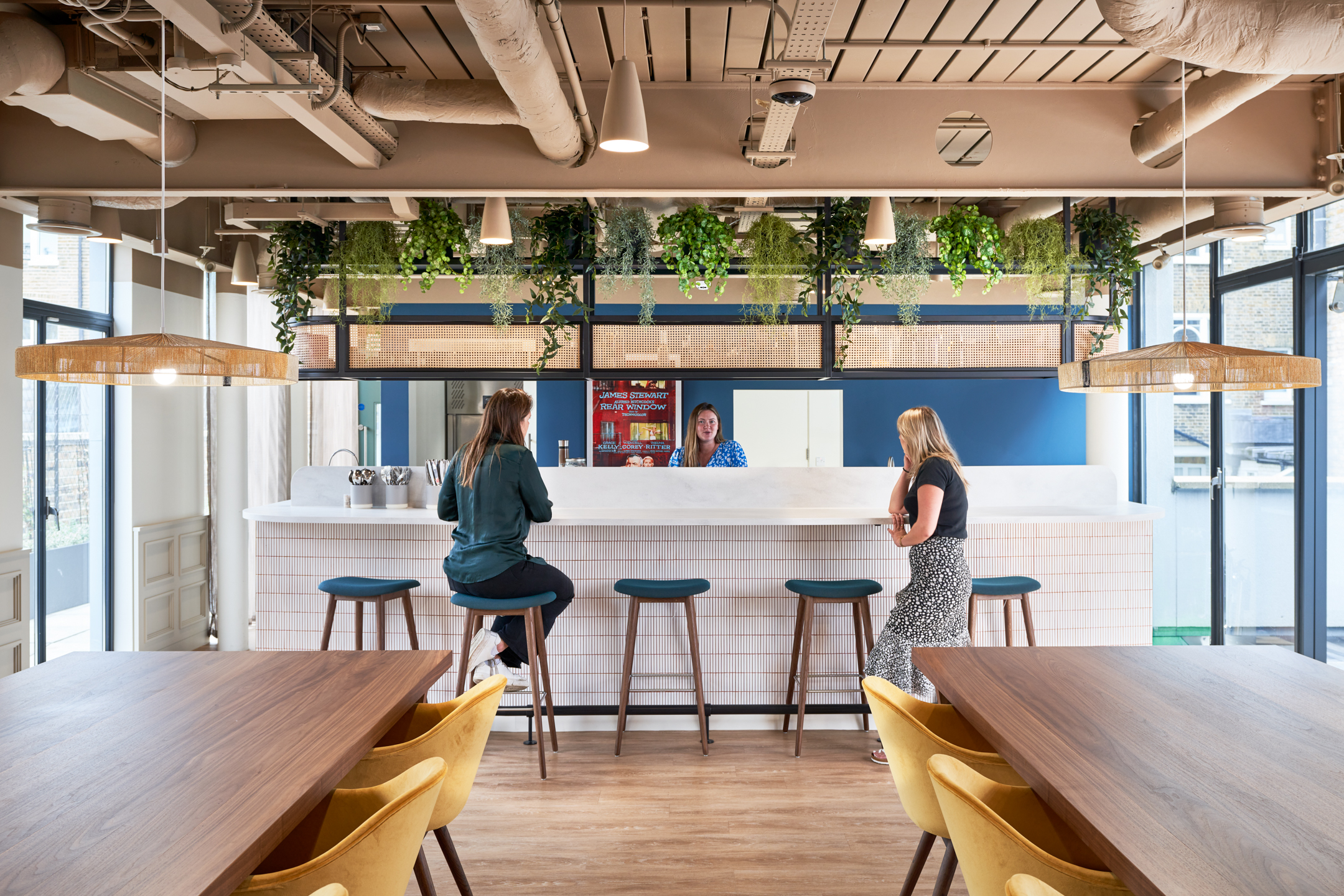 Office Design for Talent Retention TDR Workspace with a blue teapoint, high stools and hanging greenery.