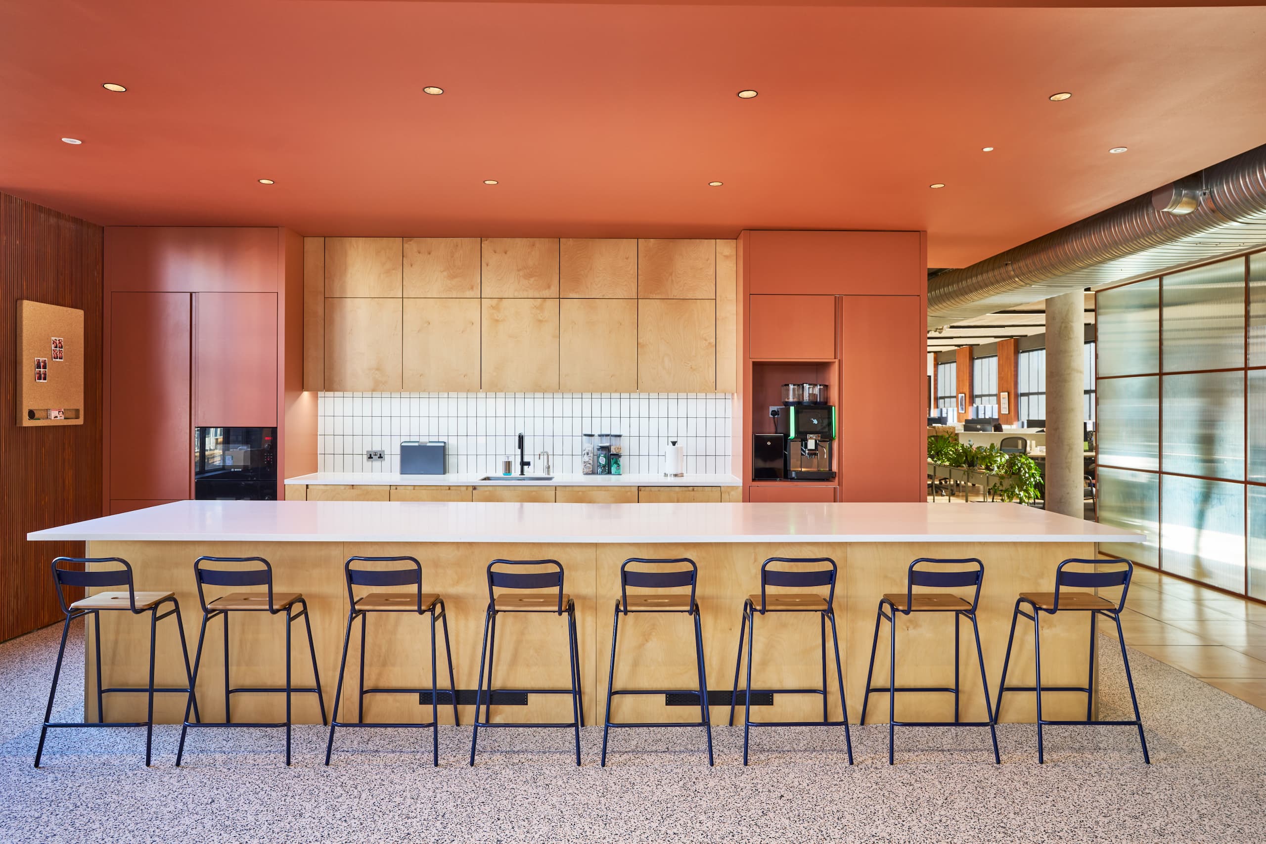 Teapoint at Joseph Joseph fitted out and refurbished space, with coral orange walls, high stools and white domile splashback tiles.