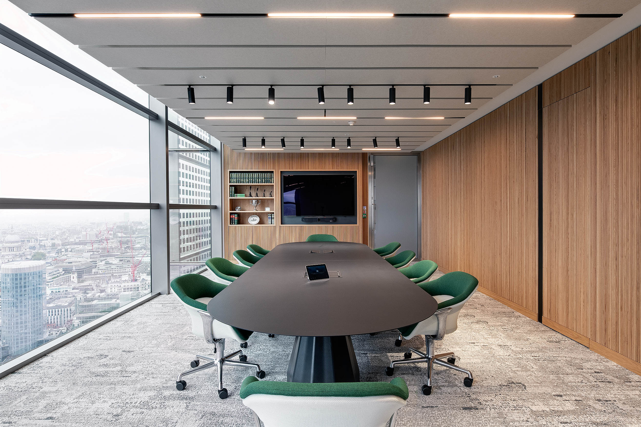 AMC Group’s meeting room with a striking modern design, green chairs, and large windows overlooking the city.