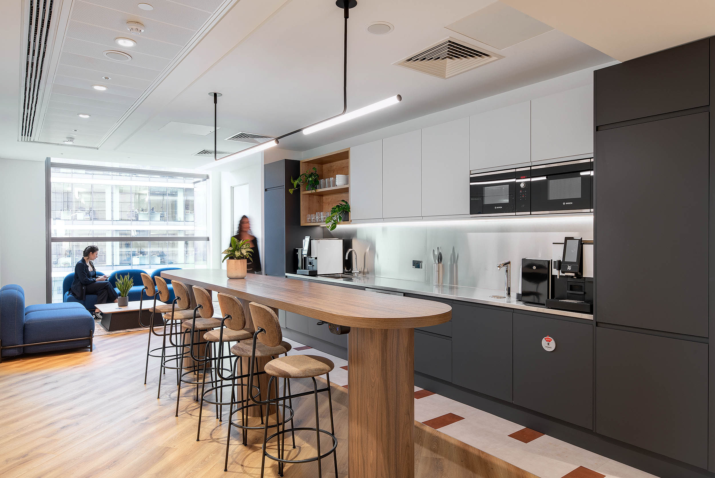 AMC Group’s teapoint with sleek appliances, a wooden countertop, and a seating area.