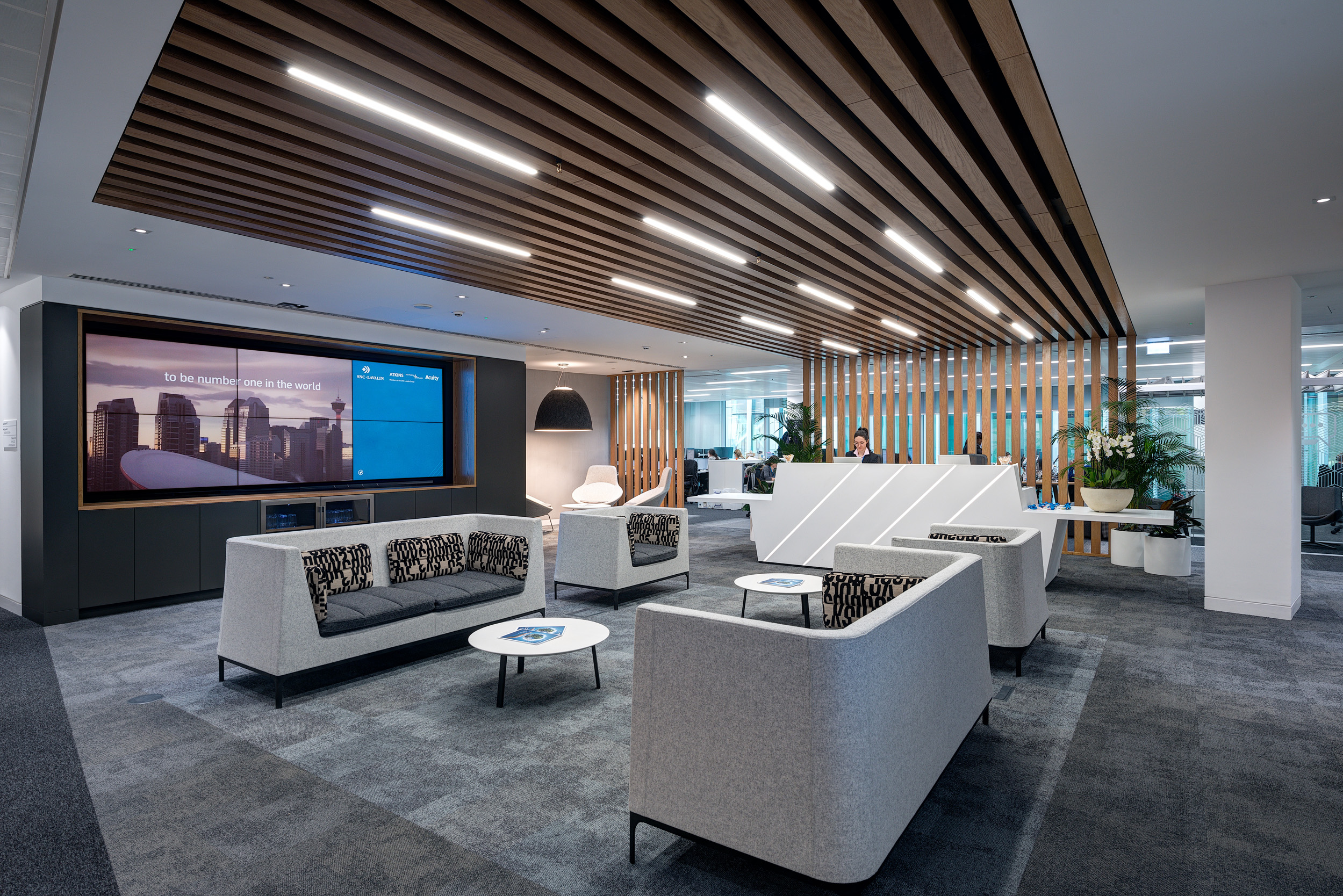 The reception area of Atkins' office at Nova North, Victoria, features a modern seating area and digital display for a welcoming first impression.