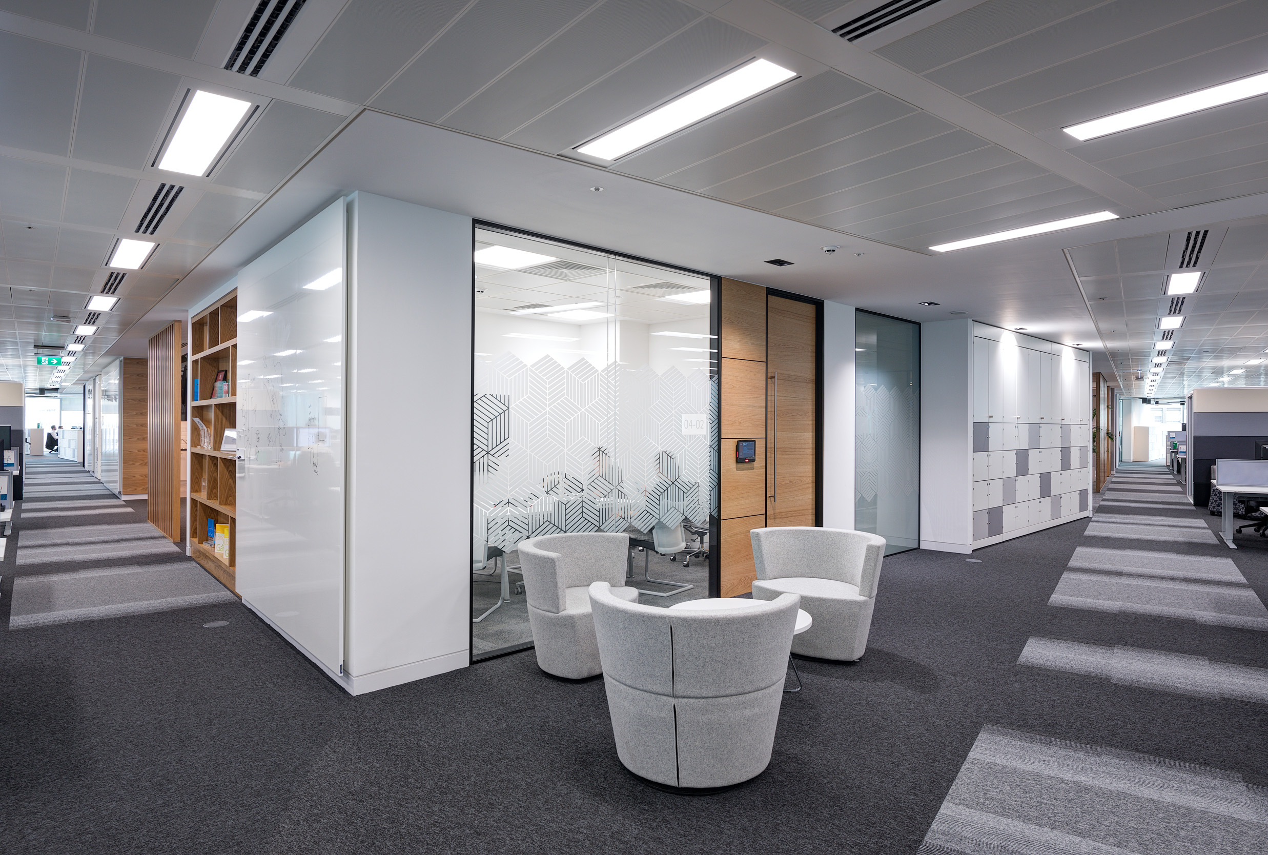A corridor at Atkins' Nova North building displays sleek glazed meeting rooms and a breakout space.