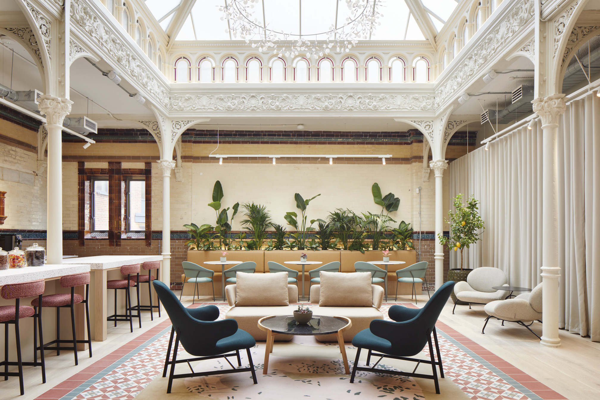 Elegant co-working space at Fora Greencoat Place, designed by Modus, featuring a beautifully restored atrium with intricate architectural details, comfortable seating, and lush greenery, creating a serene and inspiring environment for work.