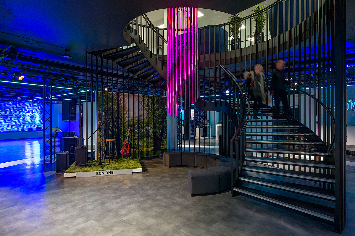 Underneath the spiral staircase at Harman's new office is a small performing stage with musical instruments and curved seating.