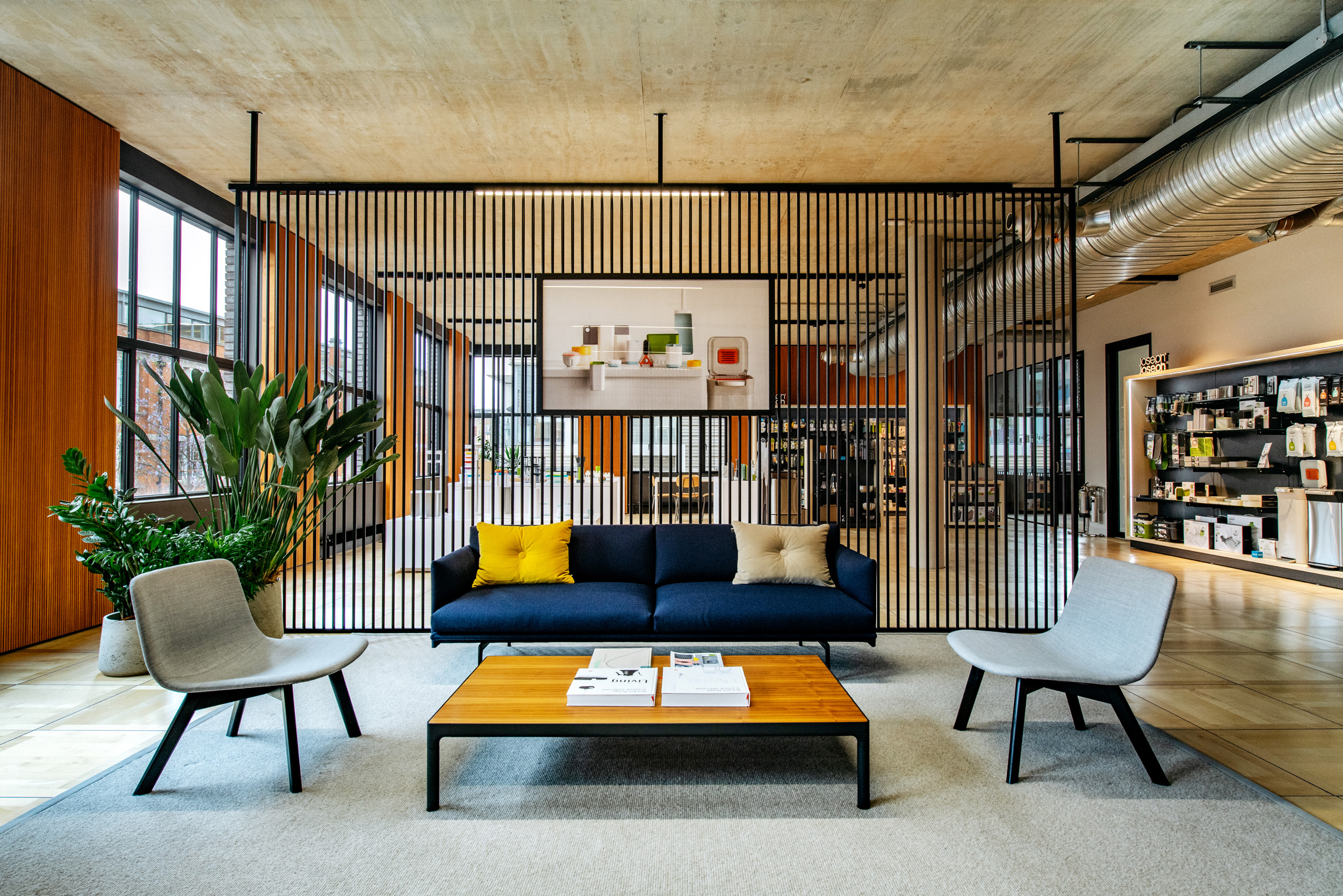 Joseph Joseph open reception seating area, with a large blue sofa and yellow pillows.