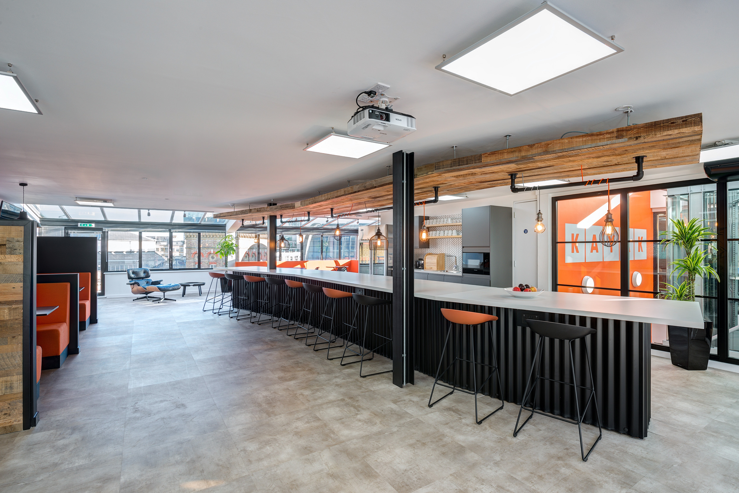 Kayak’s teapoint area, designed by Modus Workspace, features an open layout with bar-style seating and modern industrial design elements, ideal for informal meetings and relaxation.