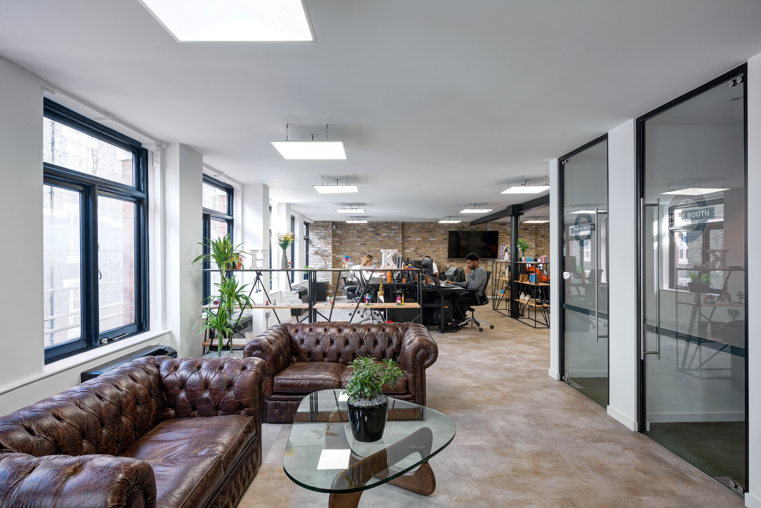 Kayak's lounge area, designed by Modus Workspace, includes leather seating and glass partitions, creating a comfortable and stylish workspace that blends relaxation and productivity.
