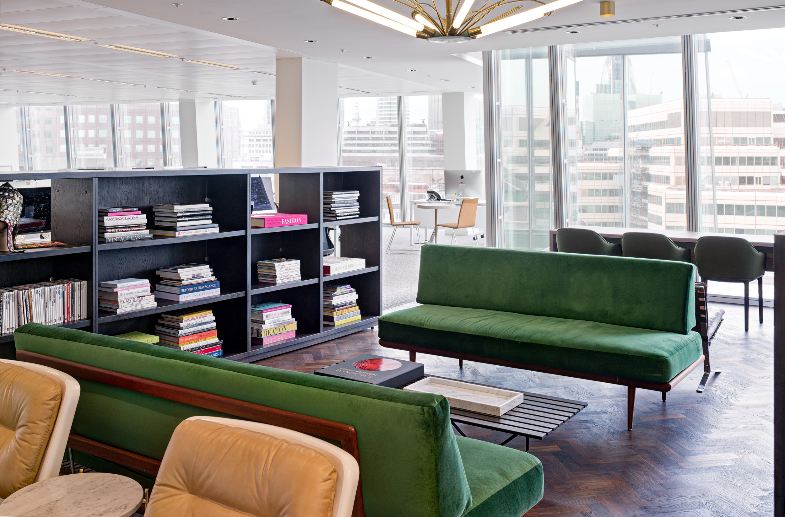 A well-lit conference room at Matches Fashion, designed by Modus Workspace, featuring a large wooden table and panoramic city views. The setting combines elegance with functionality, ideal for meetings and brainstorming sessions.