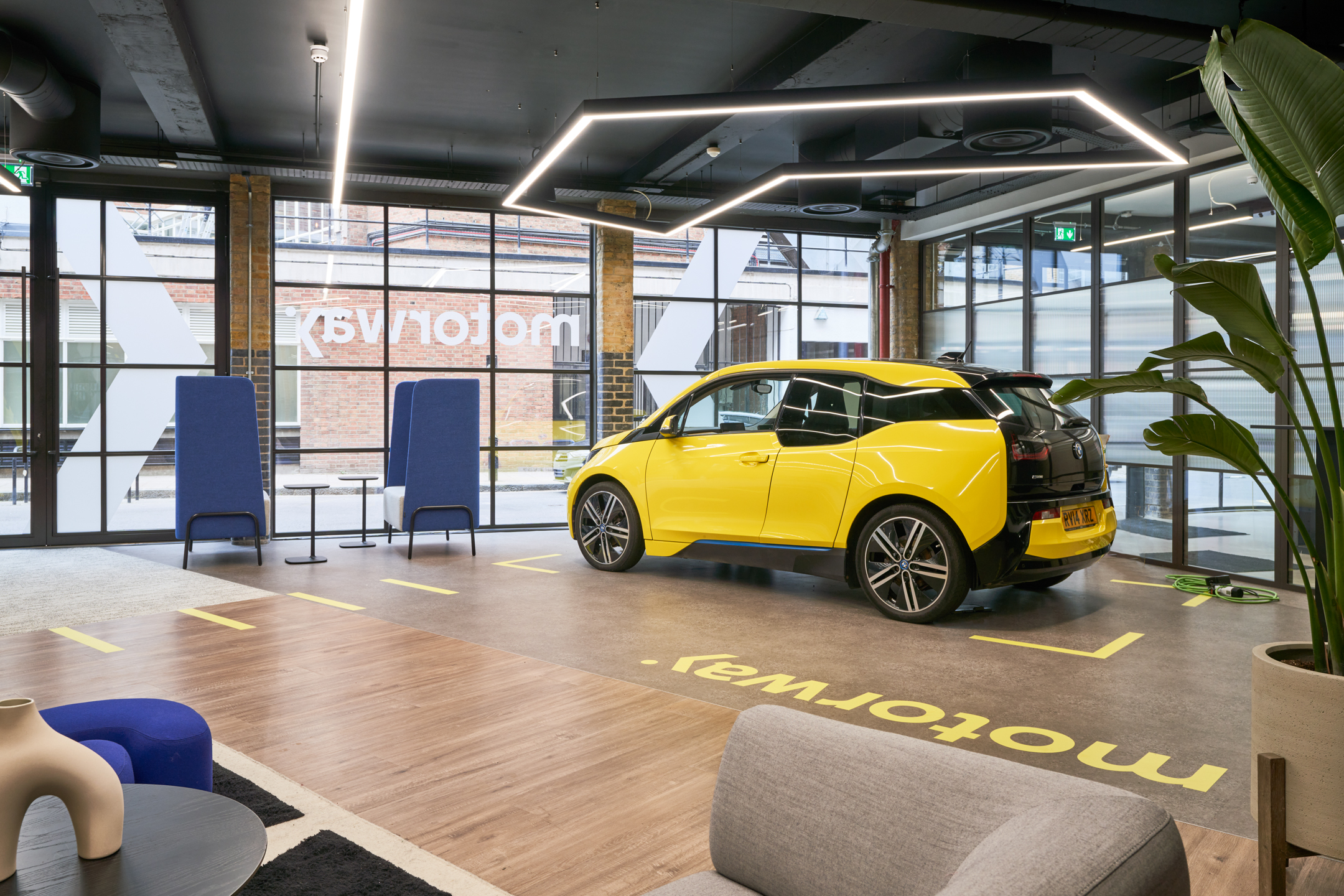 Motorway showroom with a yellow car under the spotlight