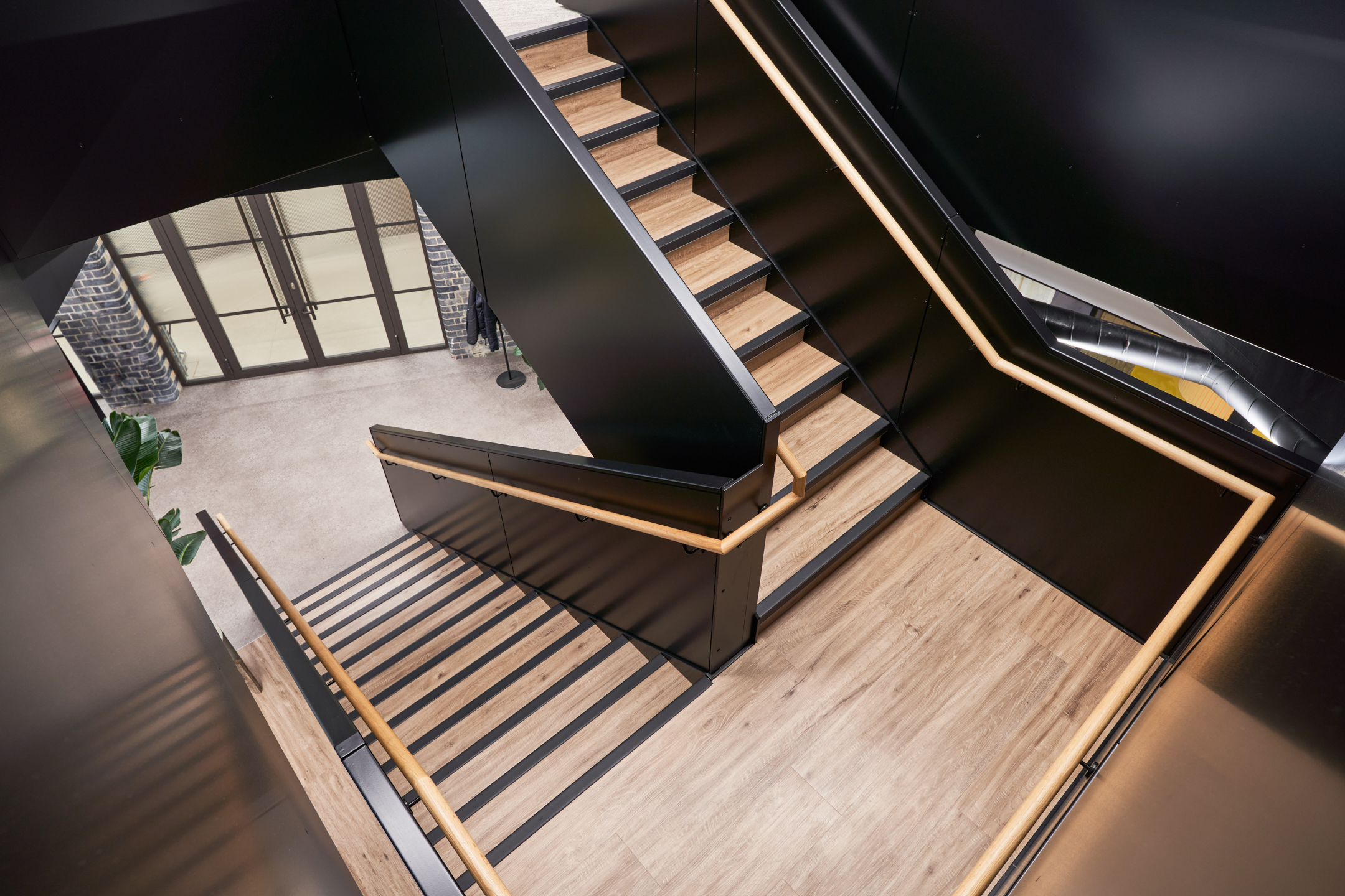 Black metal rail staircase, with oak steps and bespoke LED lighting