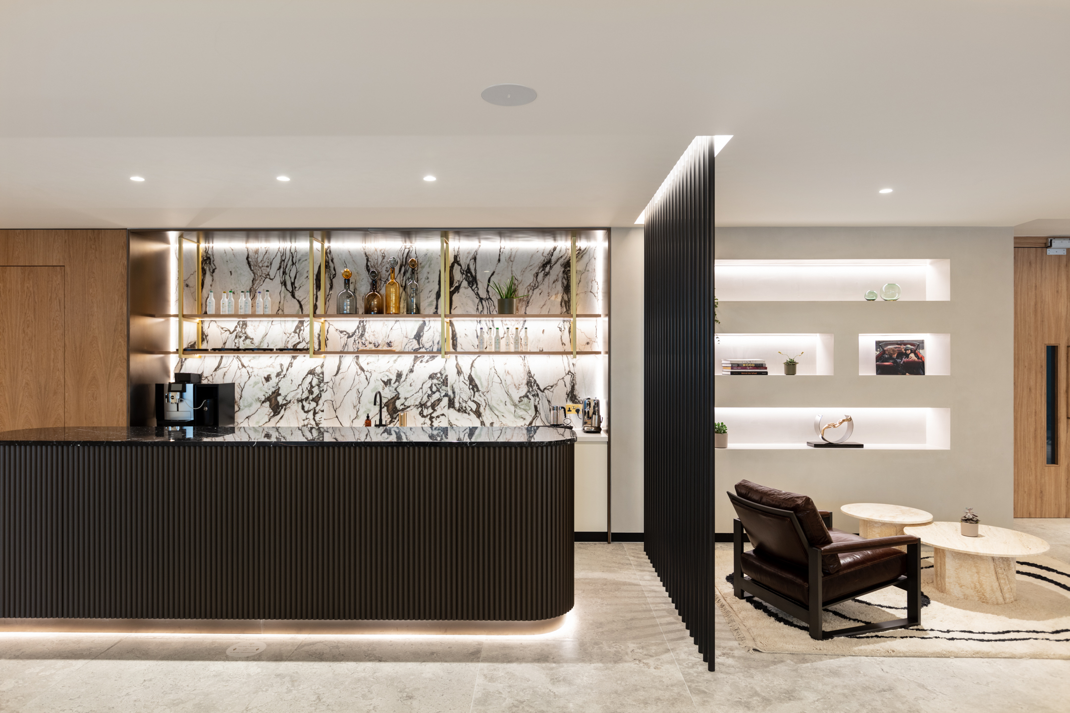 Ouronyx marble walls, with glass bottles displayed and a clean white feeling throughout.