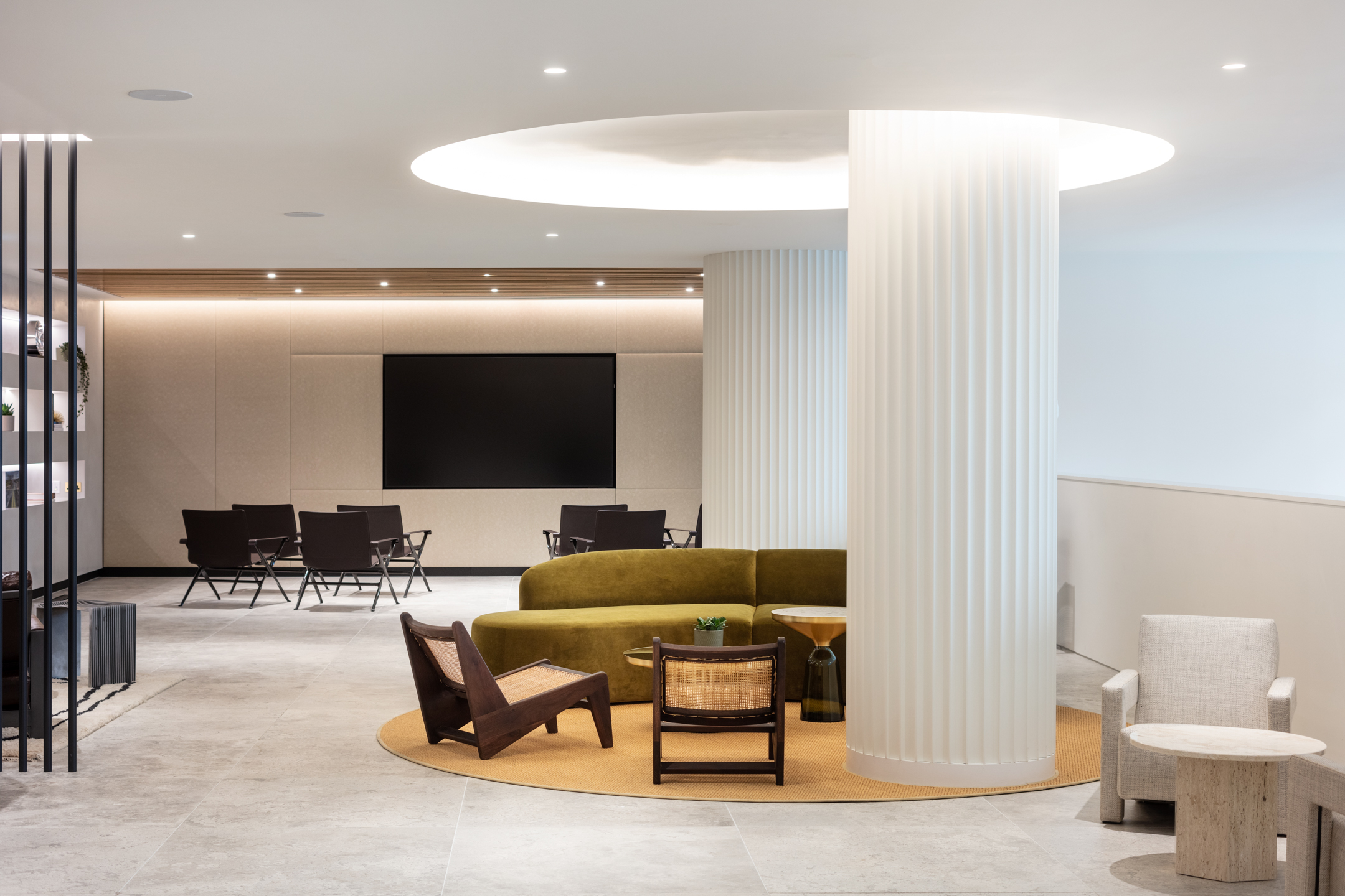 Ouronyx luxurious open-plan showroom, with large centralised pillars, sage green seating, spotlights and white bright walls.