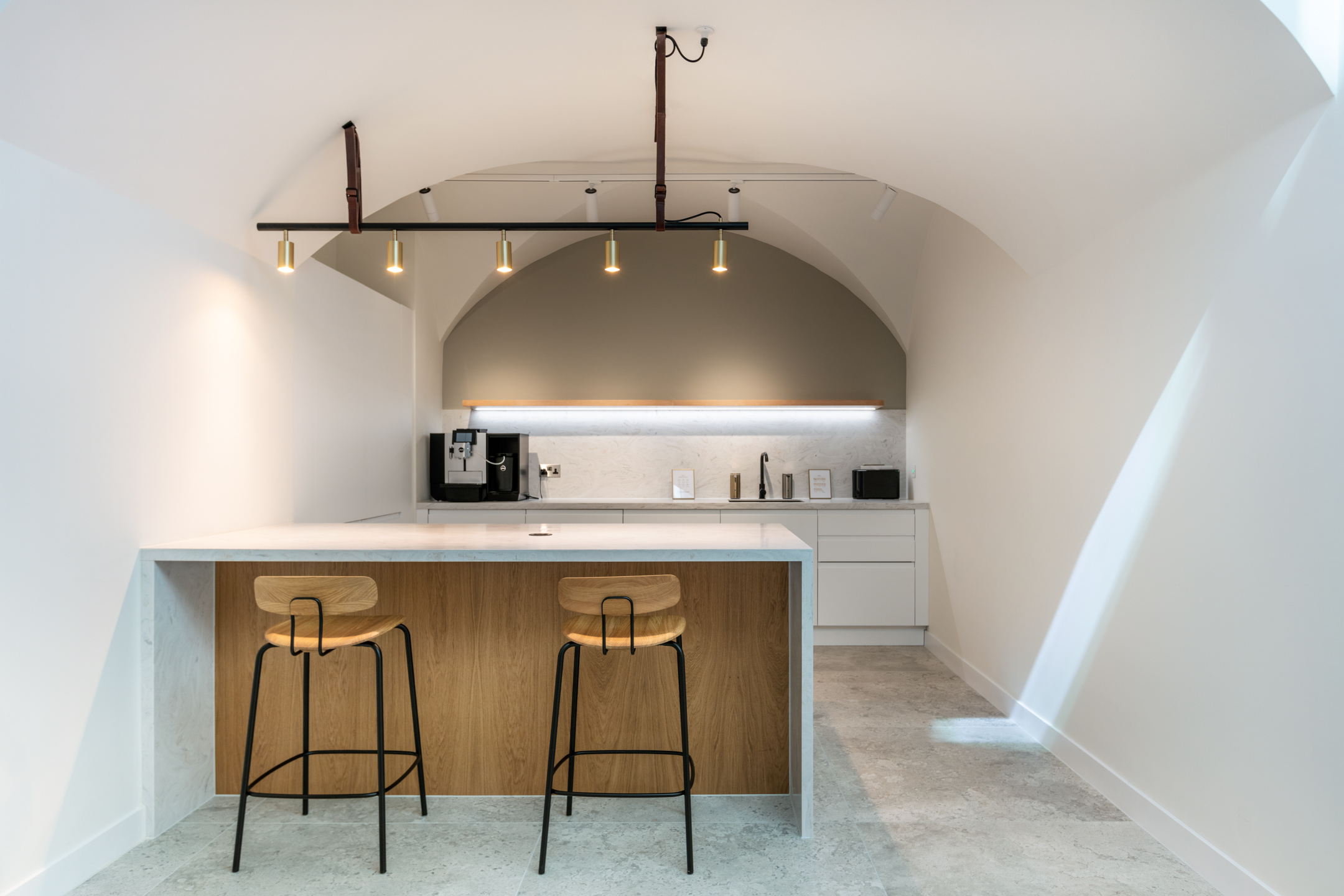 Ouronyx white teapoint area with spheric ceilings, oak high stools and spotlighting.