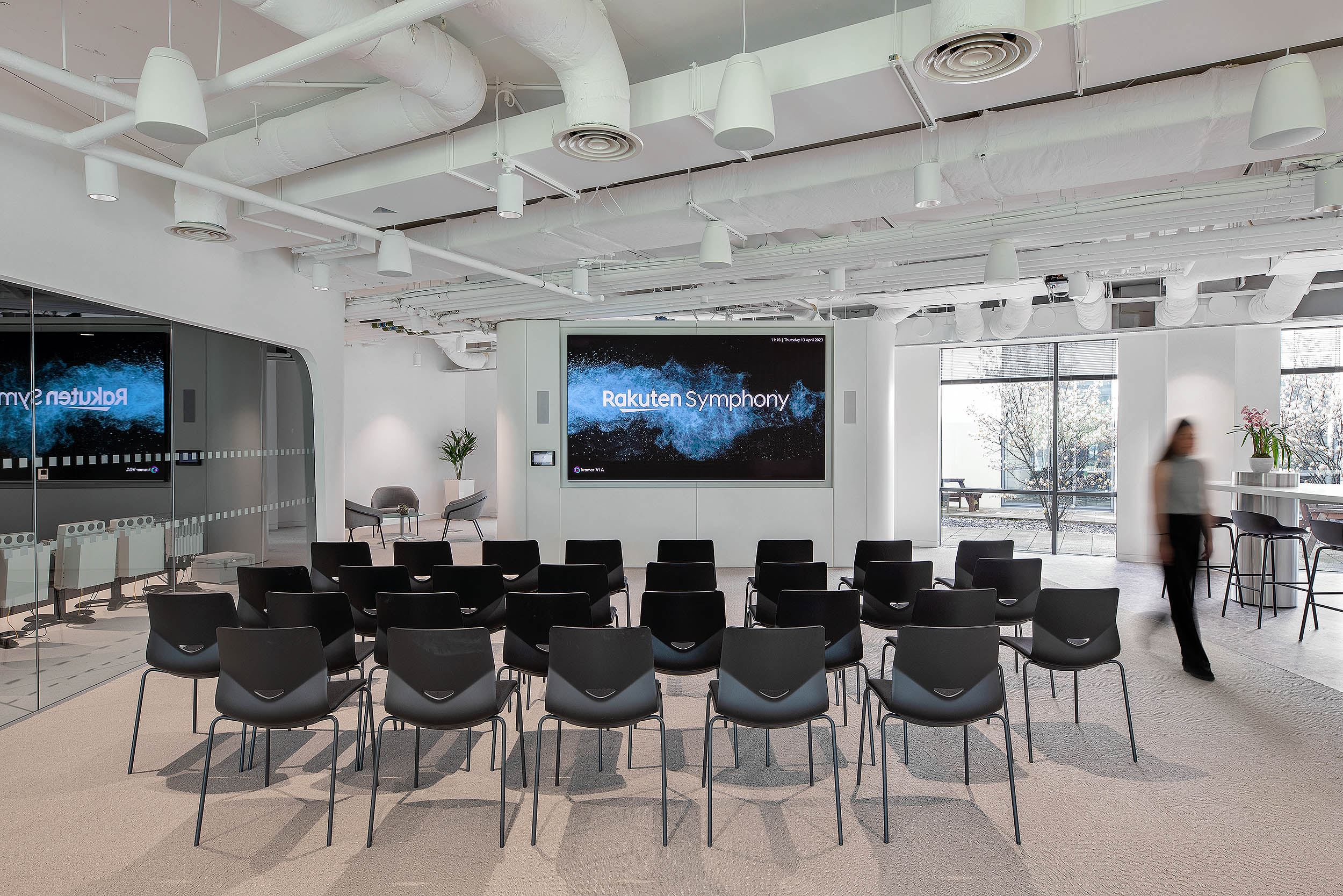 Rakuten Symphony screening room with a line of chairs and open space for presentations. The glass wall next to the space has bespoke frosted designs