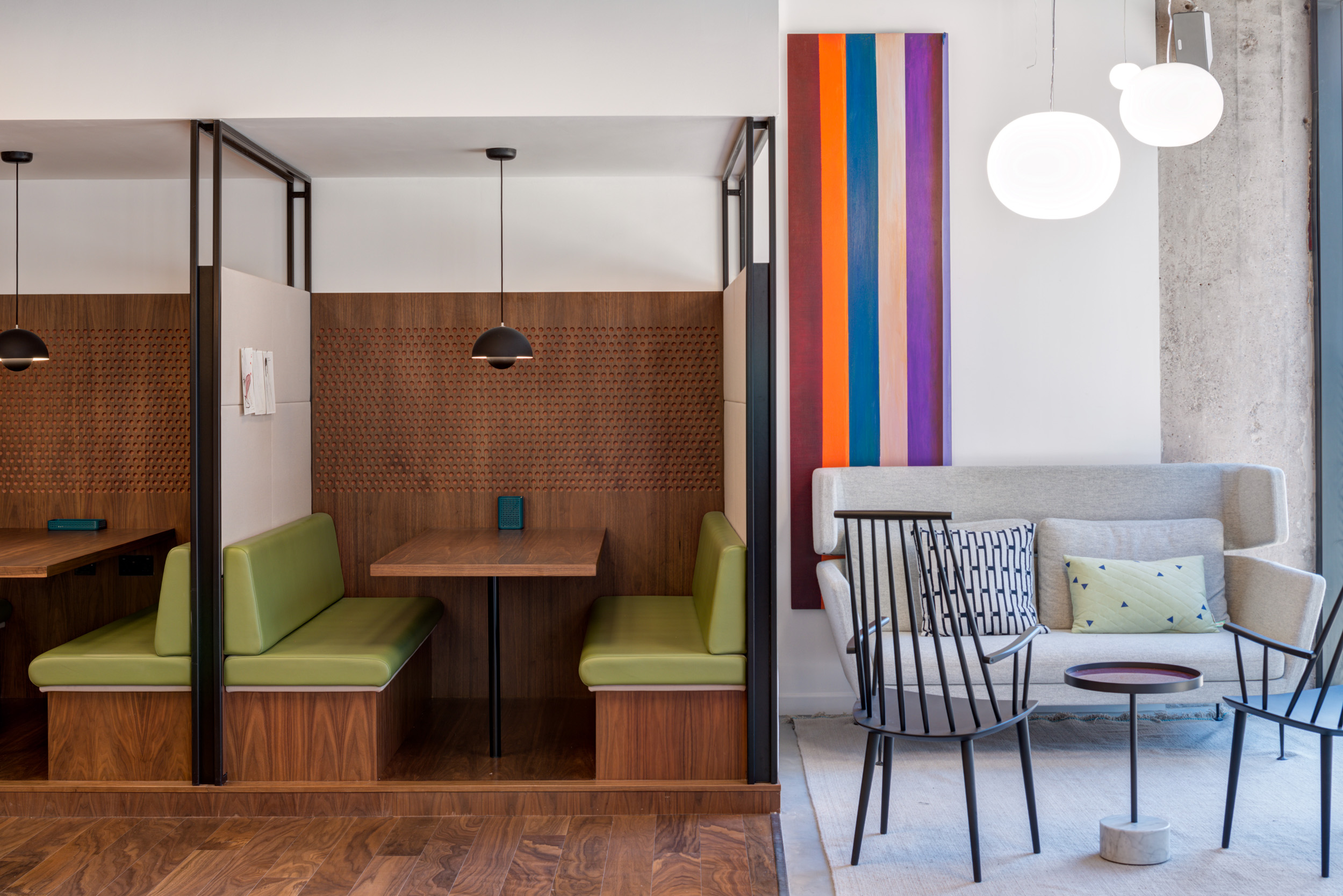 Private booth seating next to a breakout area with vibrant art at Spaces Peter House, Manchester.