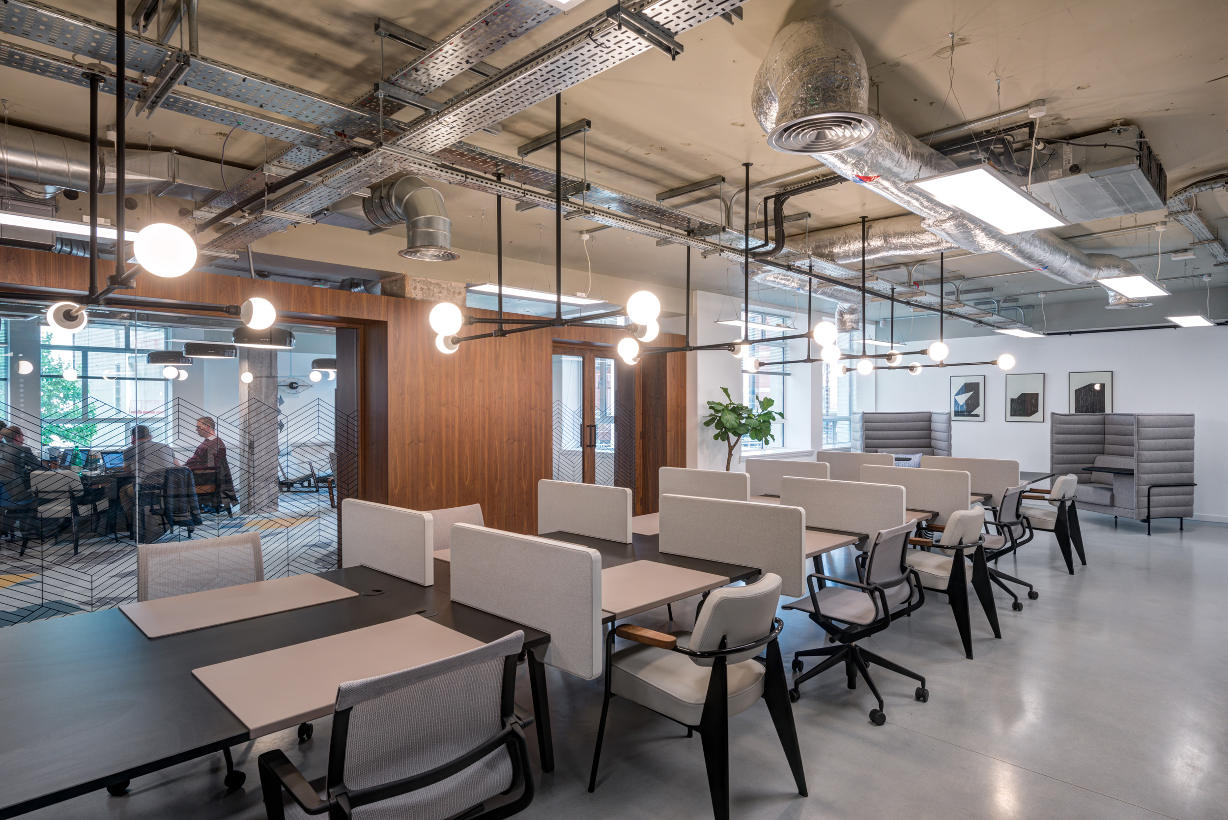 Open-plan workstations with individual desks and modern lighting, surrounded by meeting rooms at Spaces Peter House.