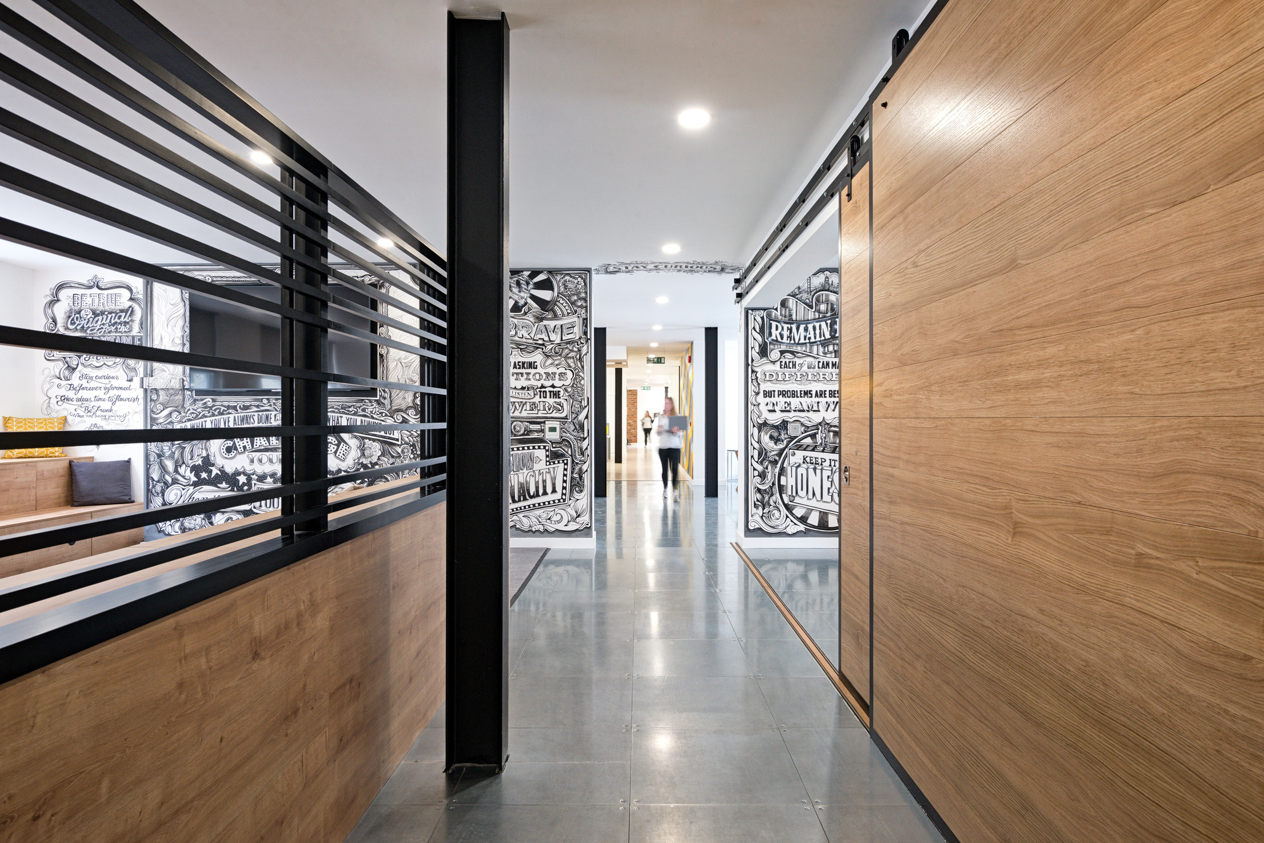 The Ruderfinn office hallway, designed by Modus Workspace, showcases bold custom artwork on the walls, creating a dynamic and creative environment.