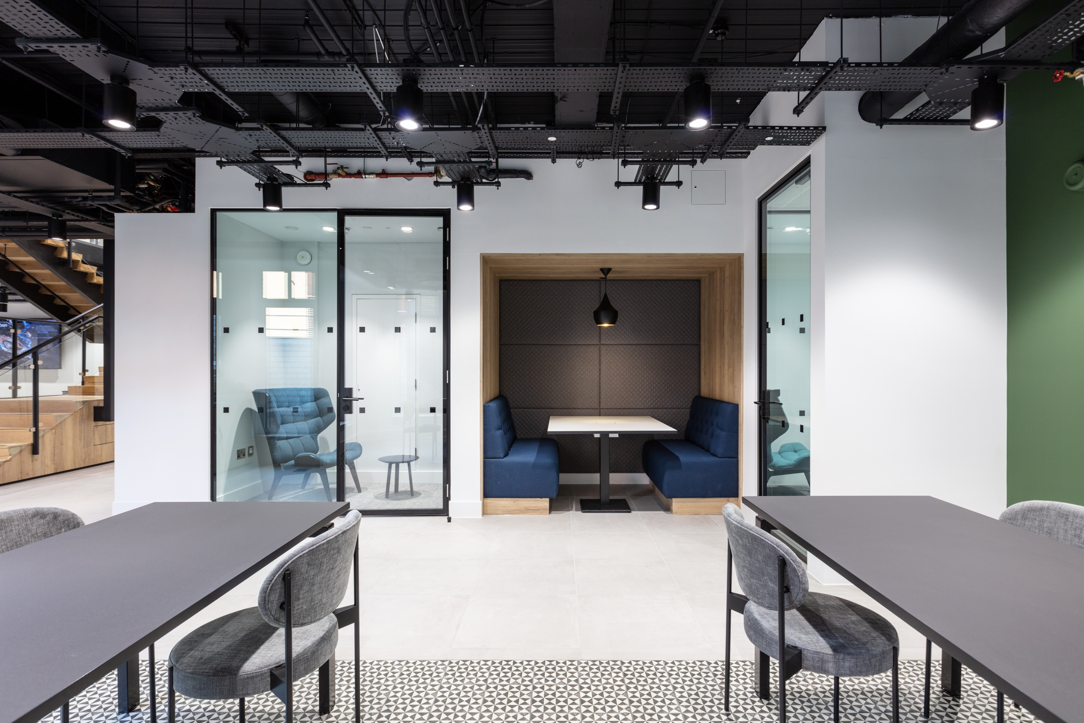 This image shows a pair of soundproof booth seating areas with blue upholstered benches and wooden accents. Designed by Modus Workspace, the space offers a comfortable environment for focused work or private conversations, perfect for collaborative meetings.