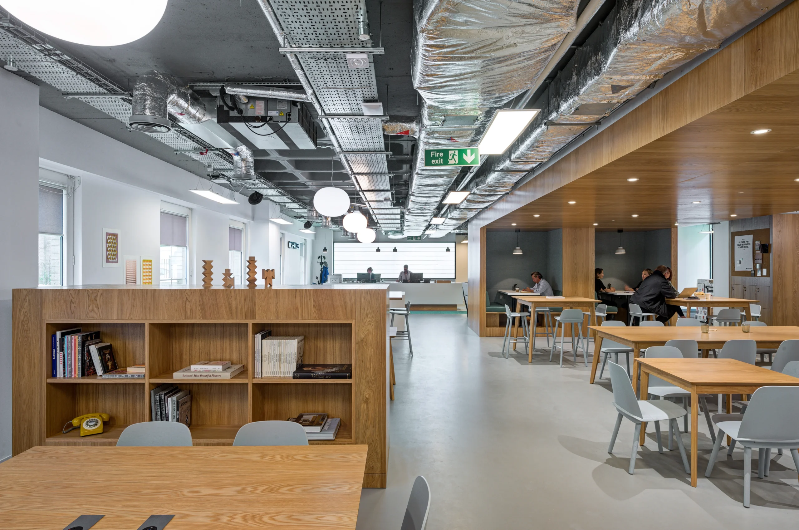 A breakout area in Spaces Mocatta House in Brighton showcases soft seating arrangements with the cafe in the background.