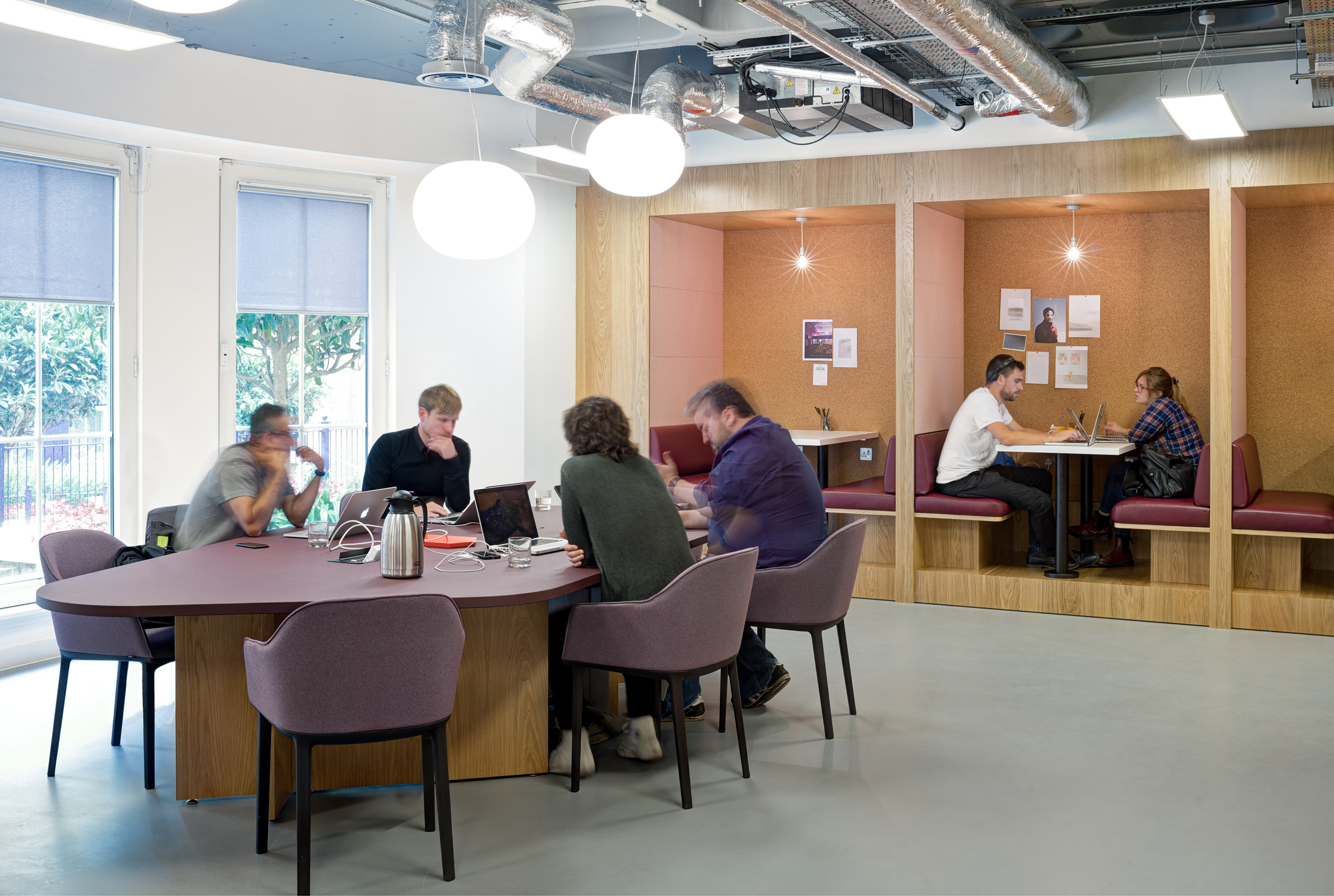 A collaborative workspace at Spaces Mocatta House in Brighton, with informal seating arrangements and dedicated focus booths, encourages a mix of teamwork and individual work.