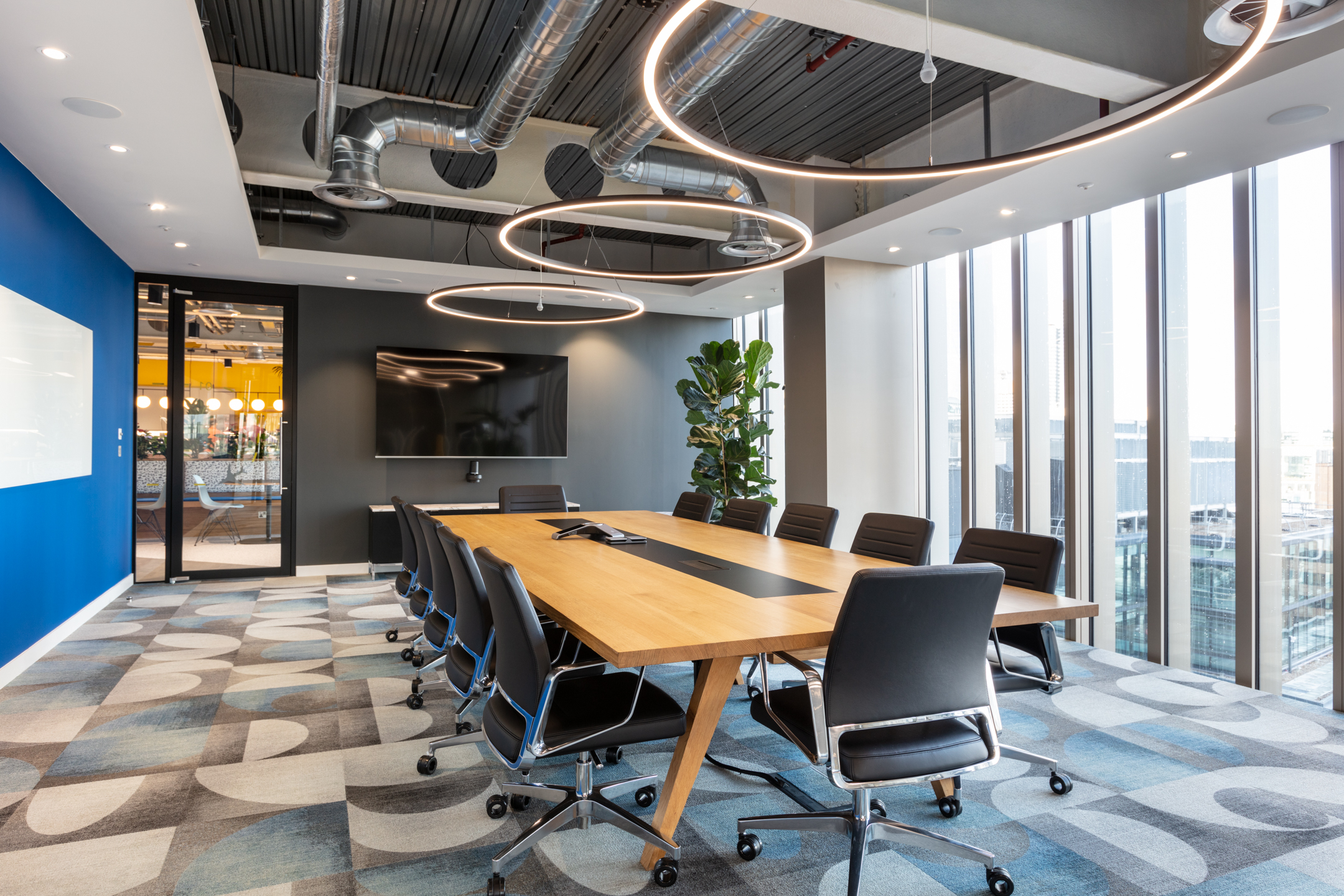 Travelfusion large meeting room with large hanging lights, bespoke flooring, and an immersive view over the City of London.