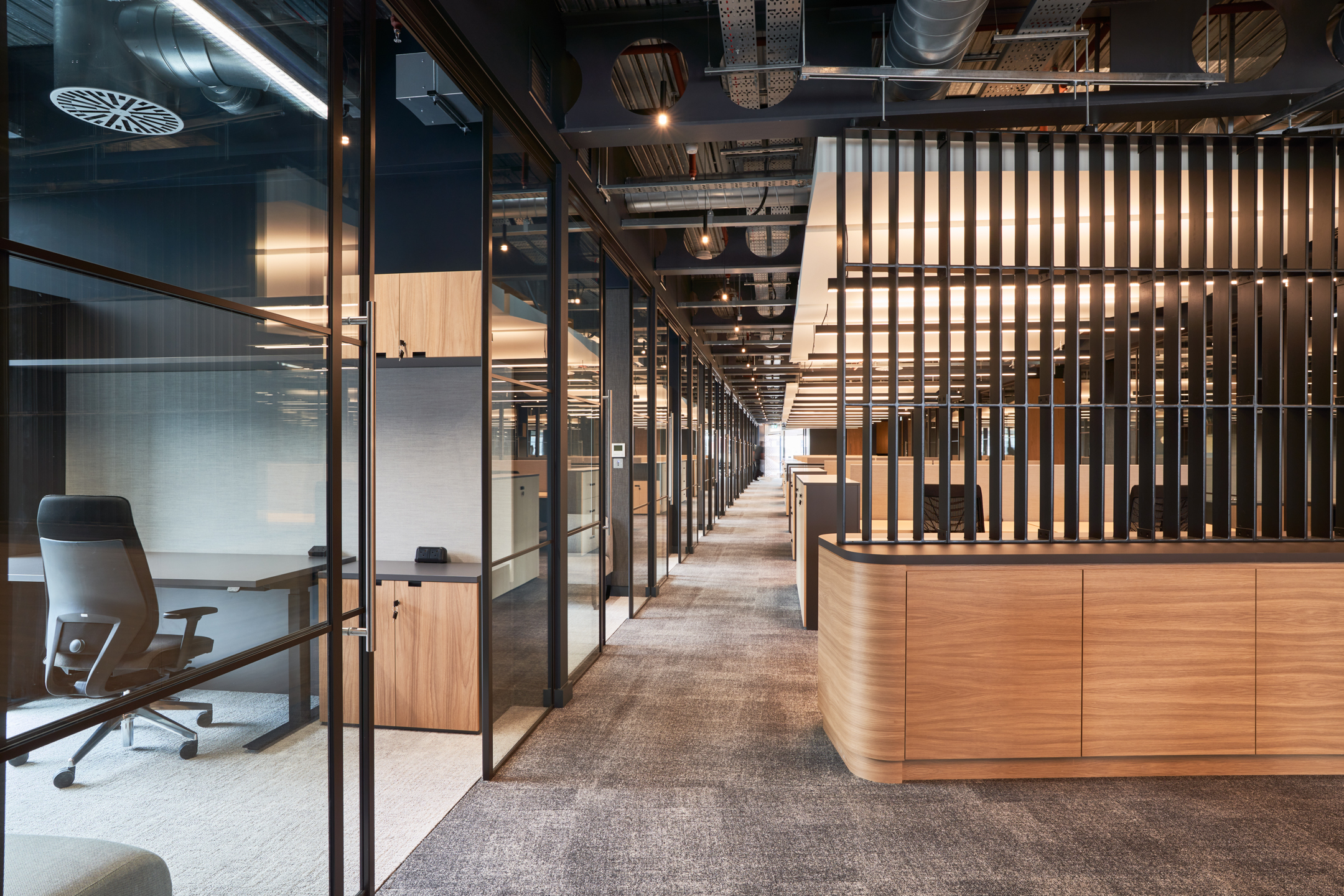 UTA’s corridor with wooden accents, glass meeting rooms and an exposed ceiling.