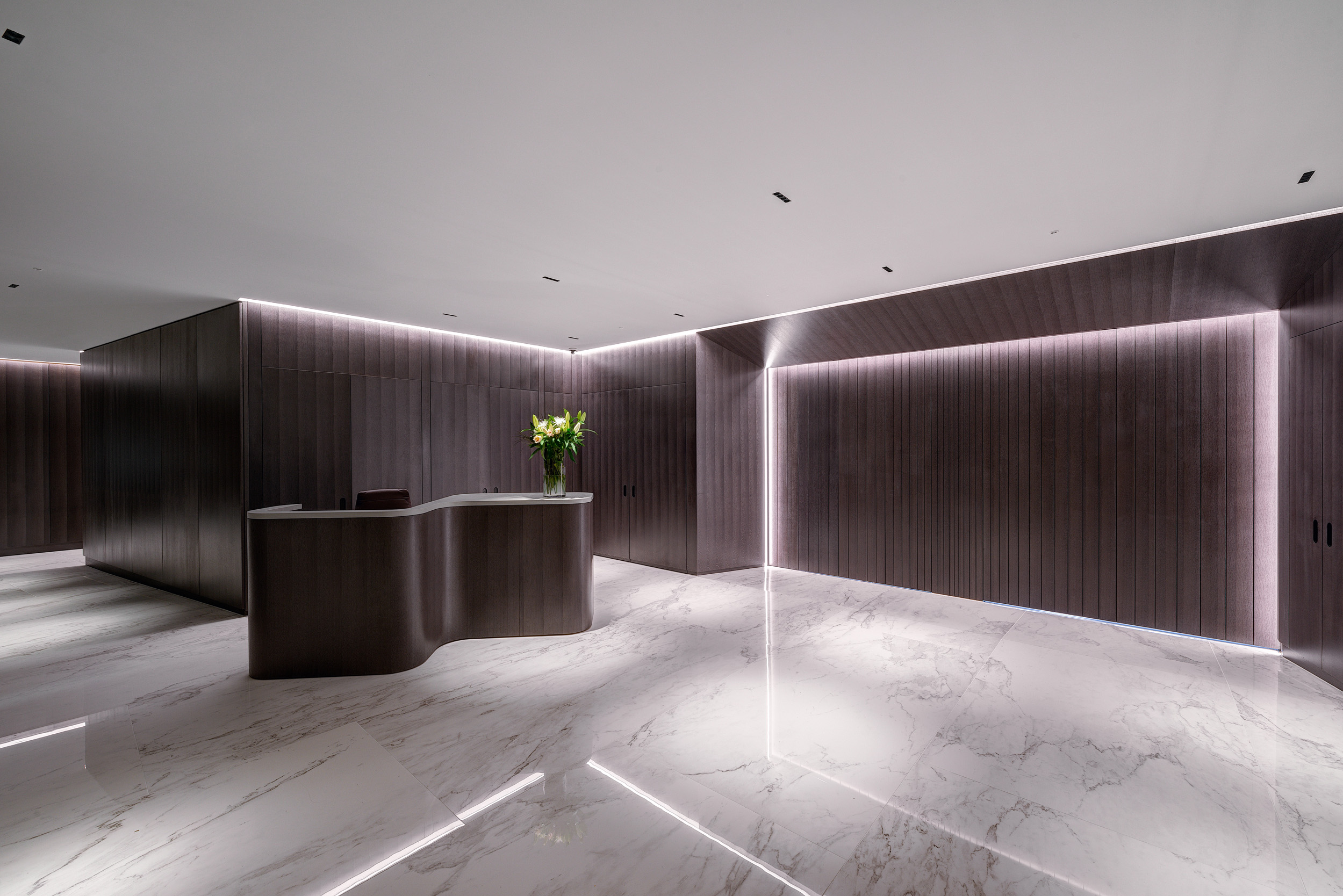 Vedanta sleek reception area, fitted out with LED lighting, marble flooring and purple panels.