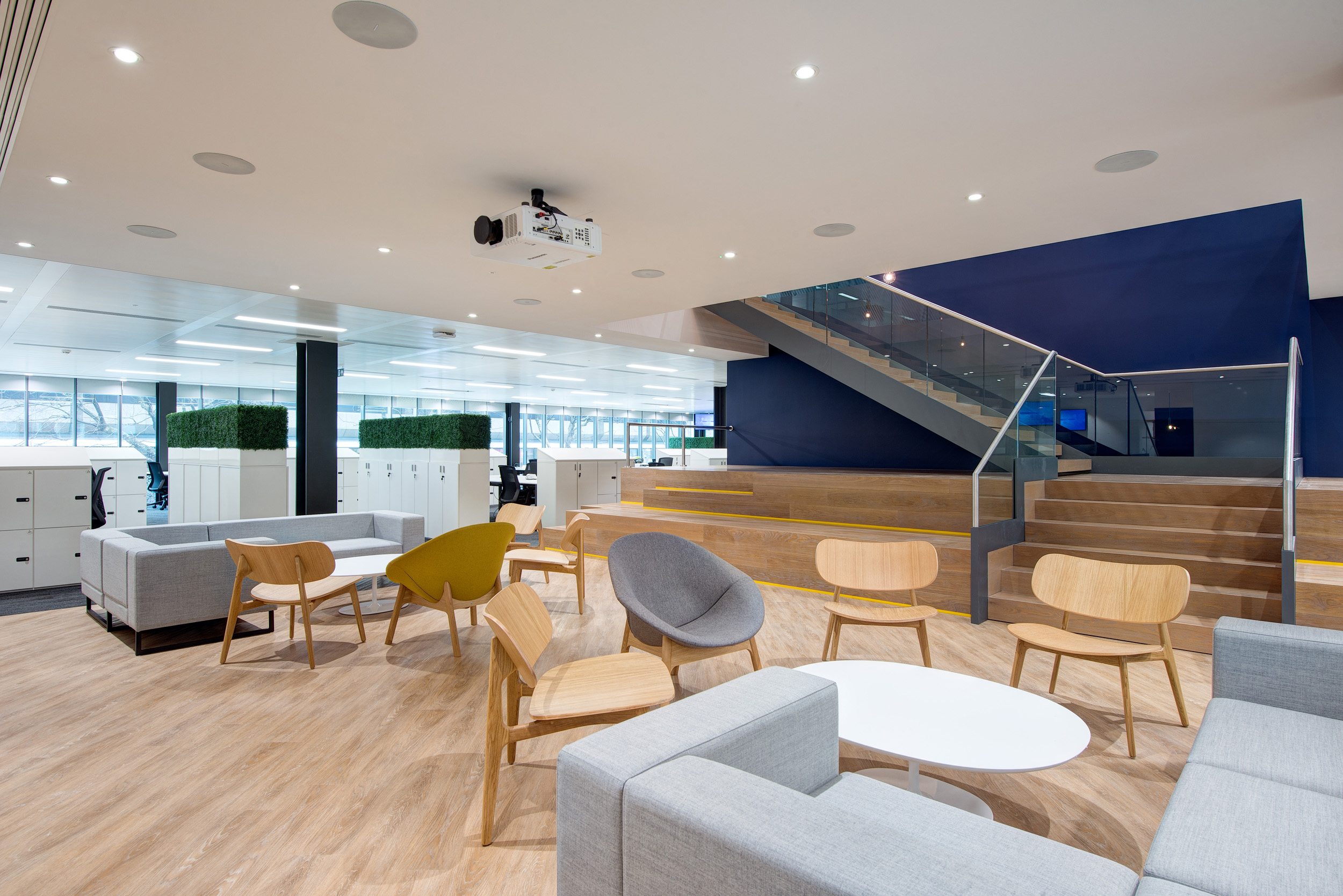 William Hill's office breakout area, designed by Modus Workspace, with comfortable seating and natural wood flooring creates a relaxing space for employees to collaborate and recharge.