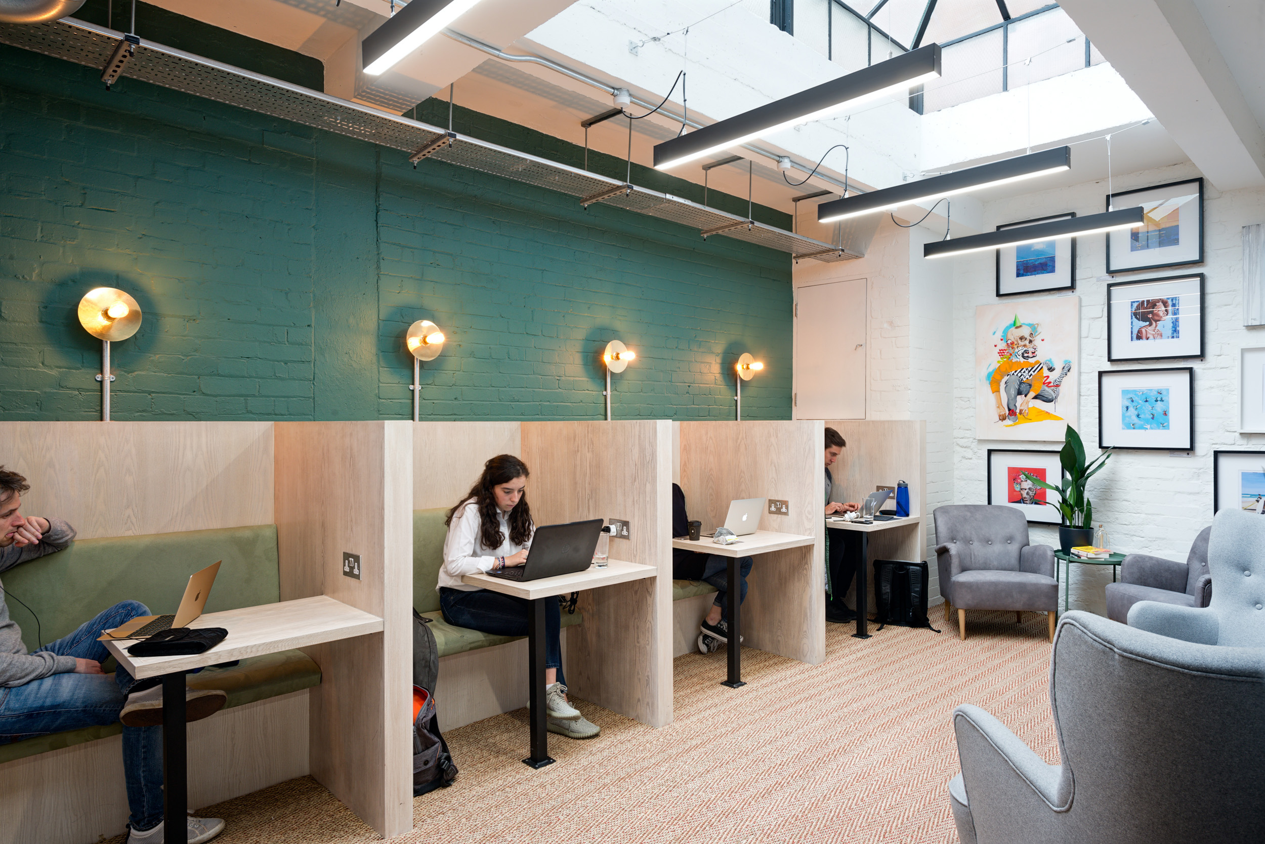 A line of private work booths, offering comfortable seating and ample lighting for focused work at Work.Life Bermondsey, designed by Modus Workspace.