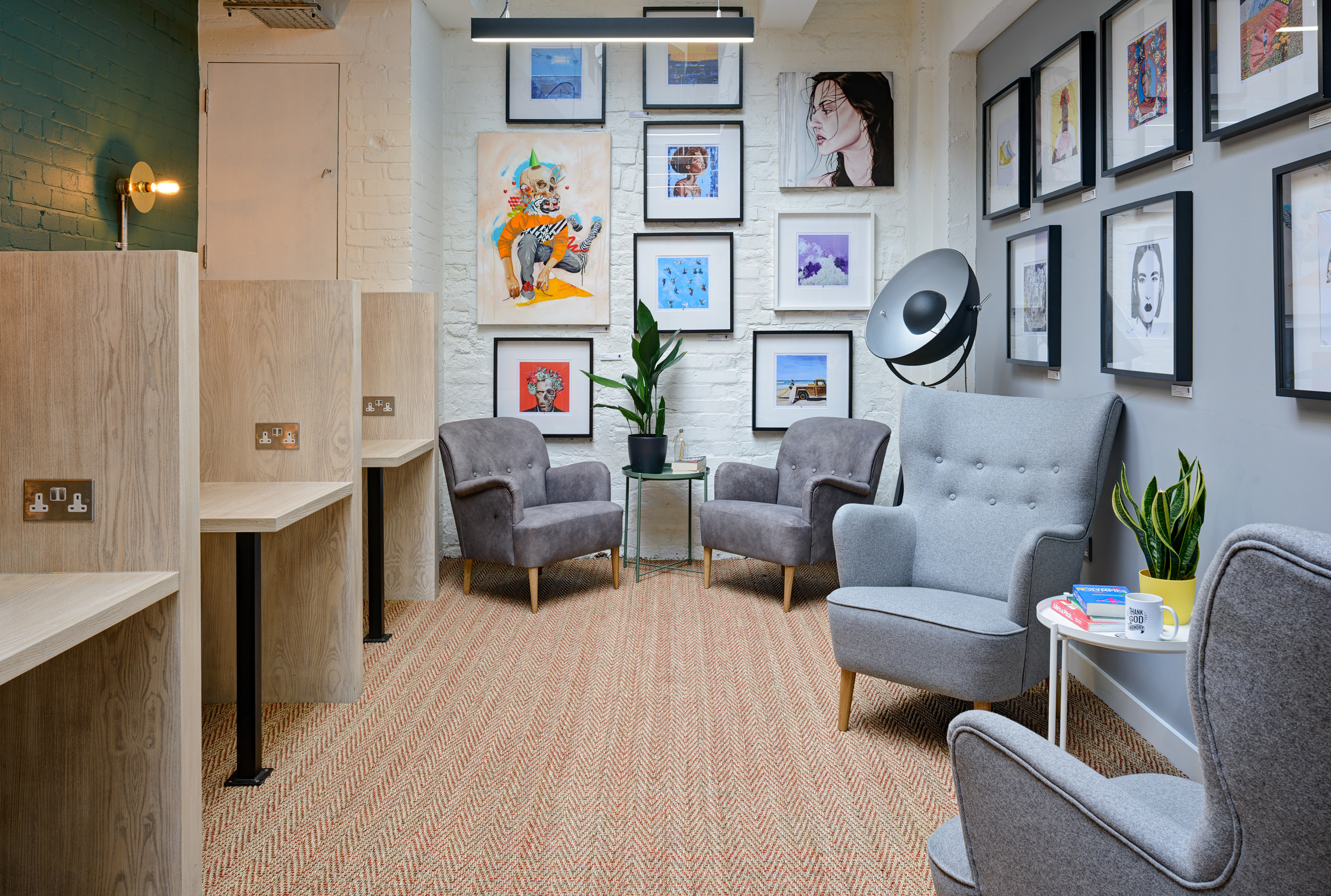 A cozy breakout space with grey armchairs and art-filled walls, creating a relaxed atmosphere at Work.Life Bermondsey, designed by Modus Workspace.