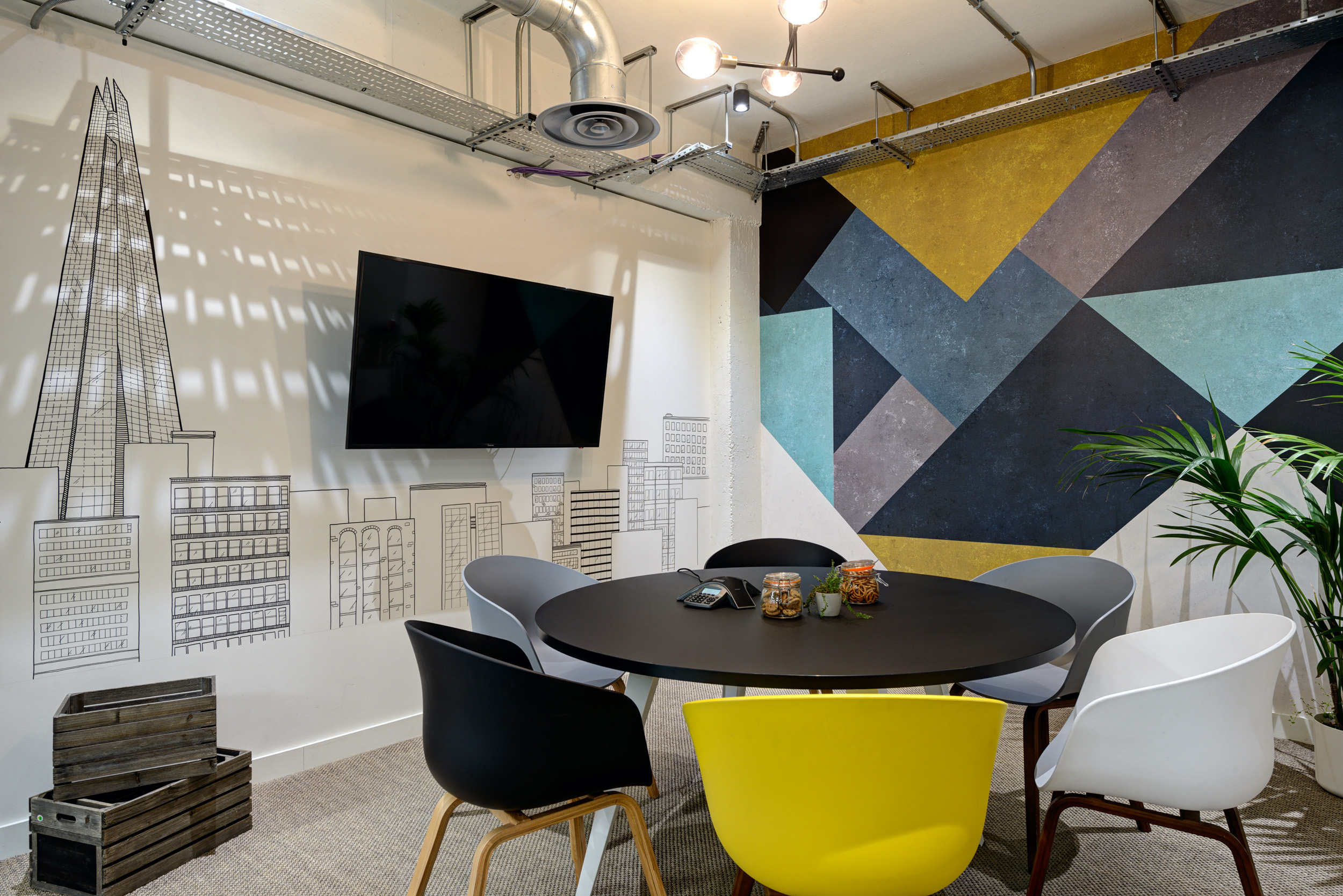 A creative meeting room featuring a hand-drawn city mural and modern seating, bringing inspiration to team collaborations at Work.Life Bermondsey, designed by Modus Workspace.