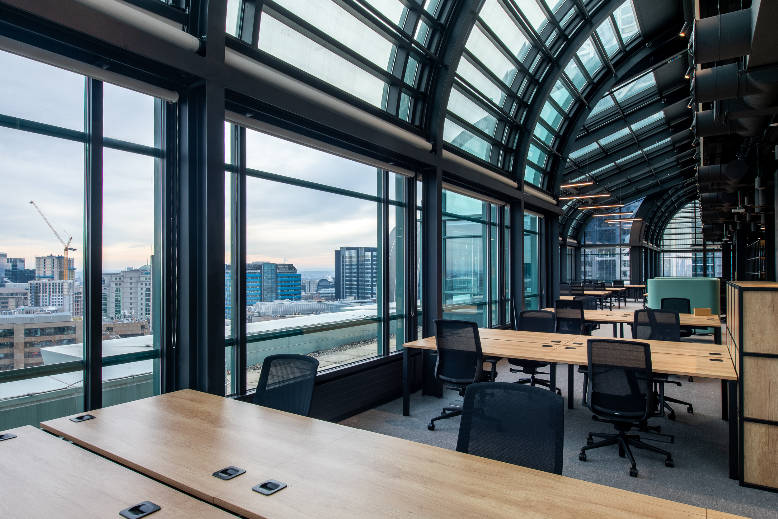 135 Bishopgate futuristic office space with an open view of London, with desking, office chairs and sleek black finishes
