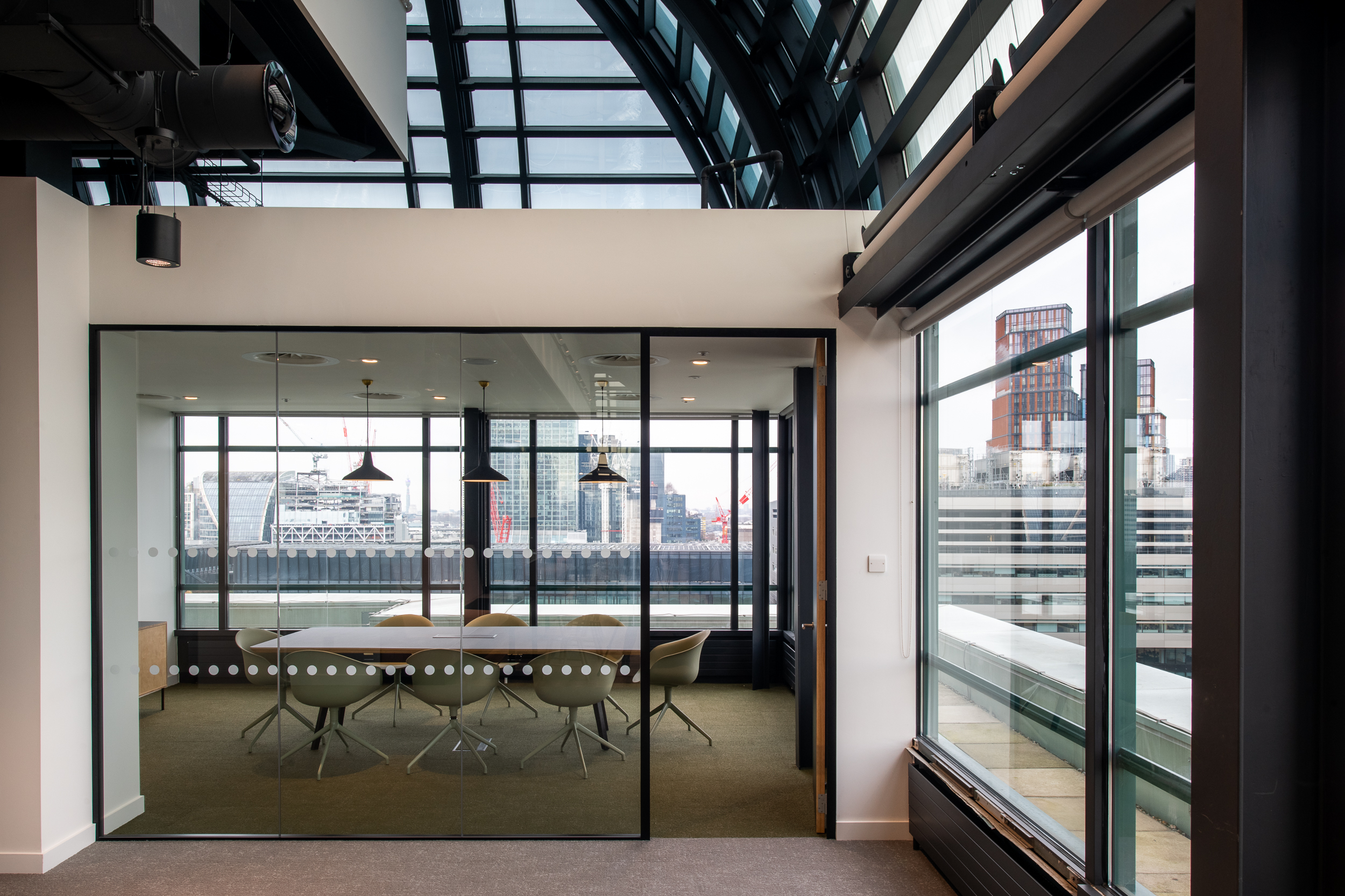 135 Bishopsgate Glass Meeting Room View, with bespoke lighting, pastel green chairs and an impressive view of London
