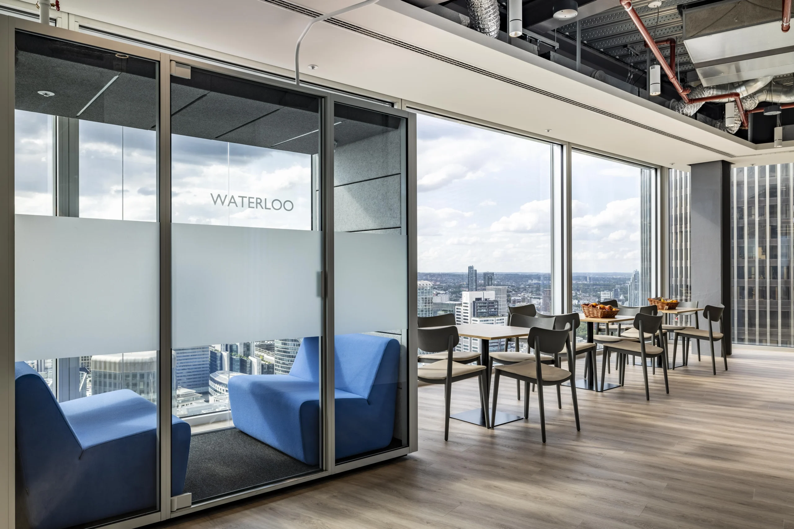 Investment Company breakout space featuring private boothes, and a seating area for collaborative or individual focus time with additional space.