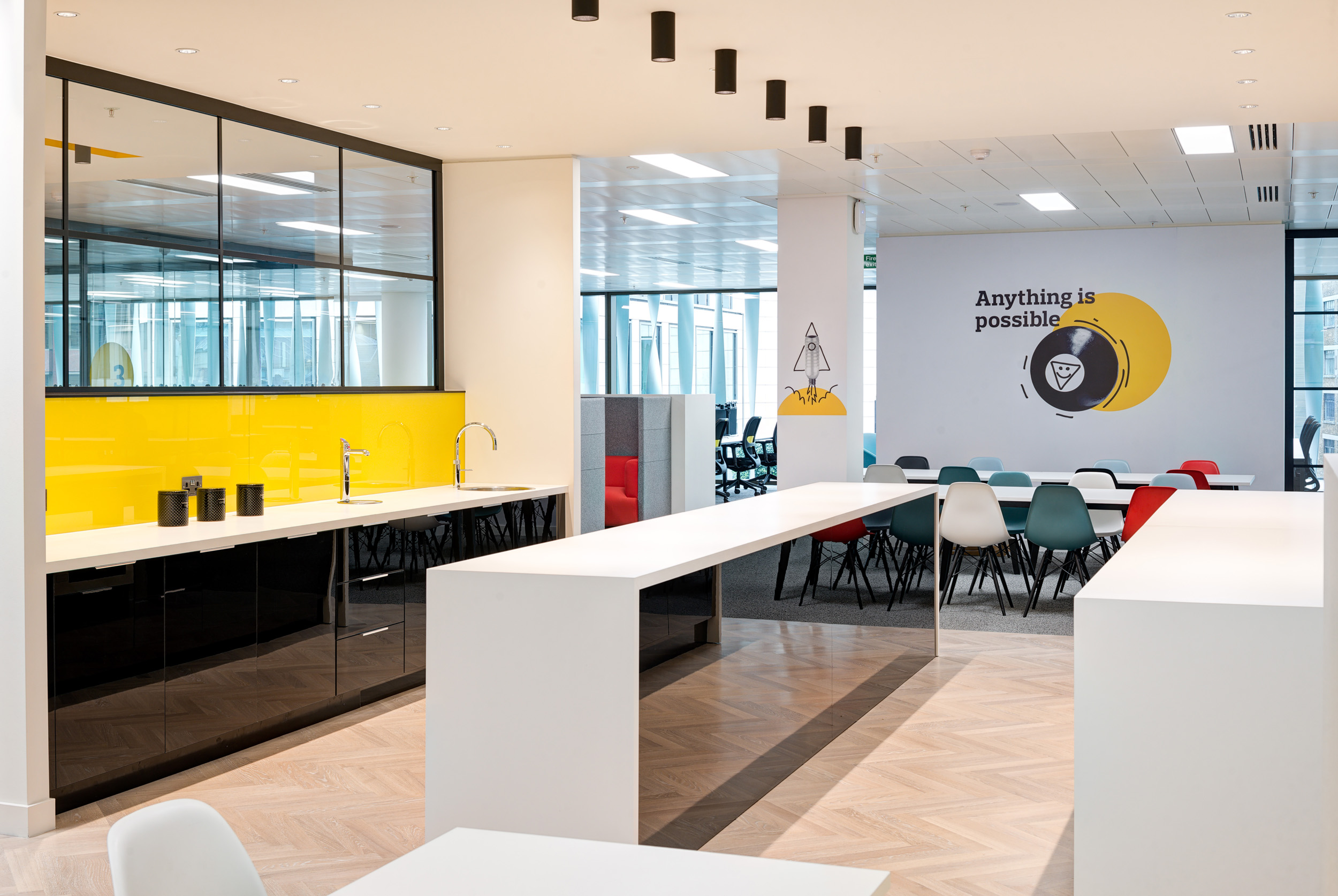Teapoint and collaboration area at Aldermore Bank, featuring vibrant yellow accents and open space for interaction.