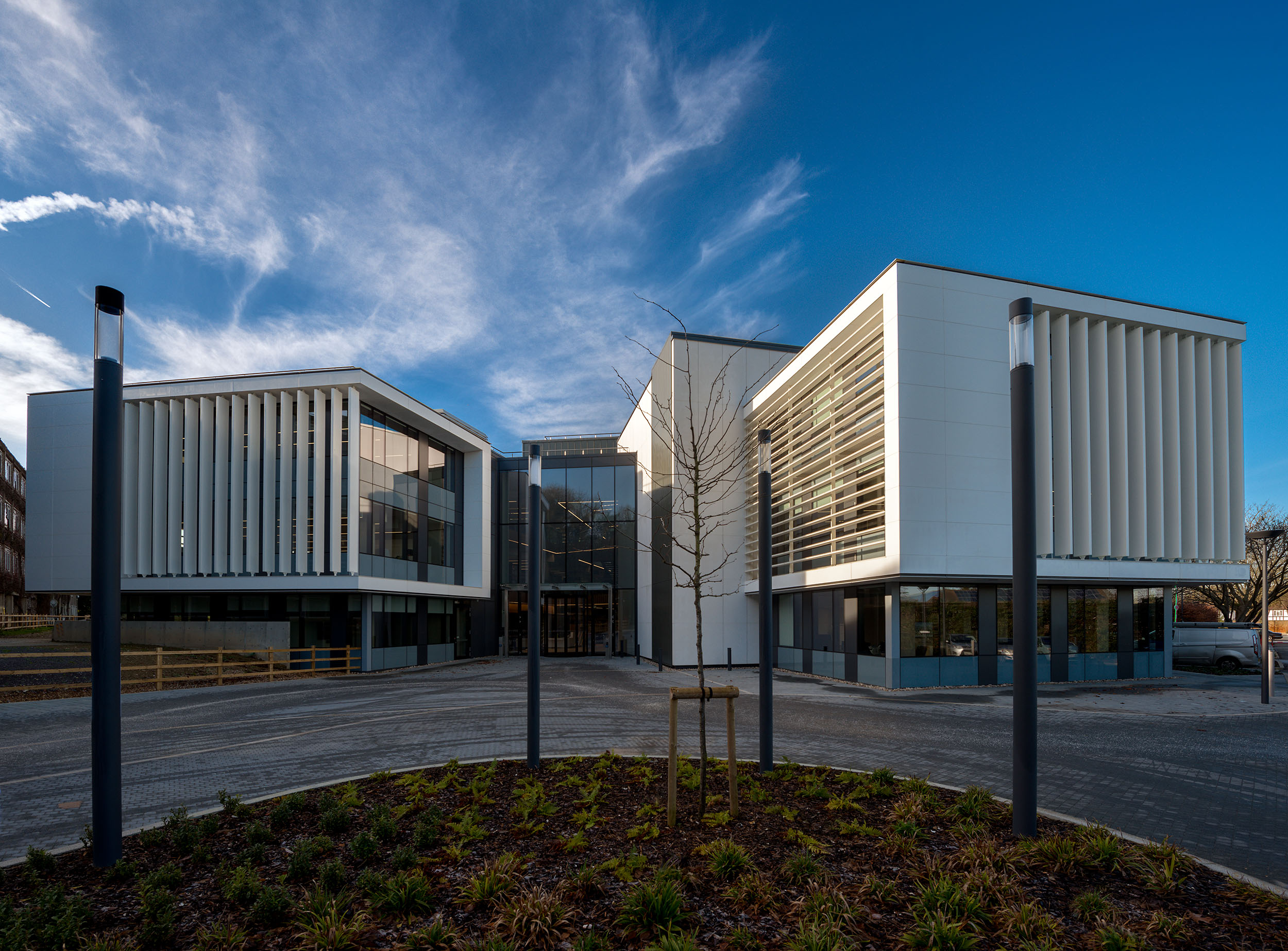 Exterior shot of the Atkins Woodcote Grove building, showcasing modern architecture with clean lines and glass façades under a blue sky.