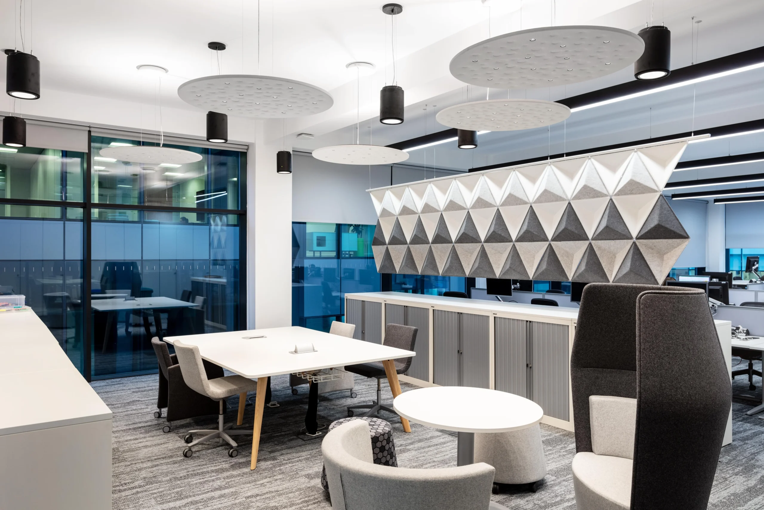 A collaborative space at Atkins featuring workstations, acoustic ceiling panels, and flexible seating solutions.