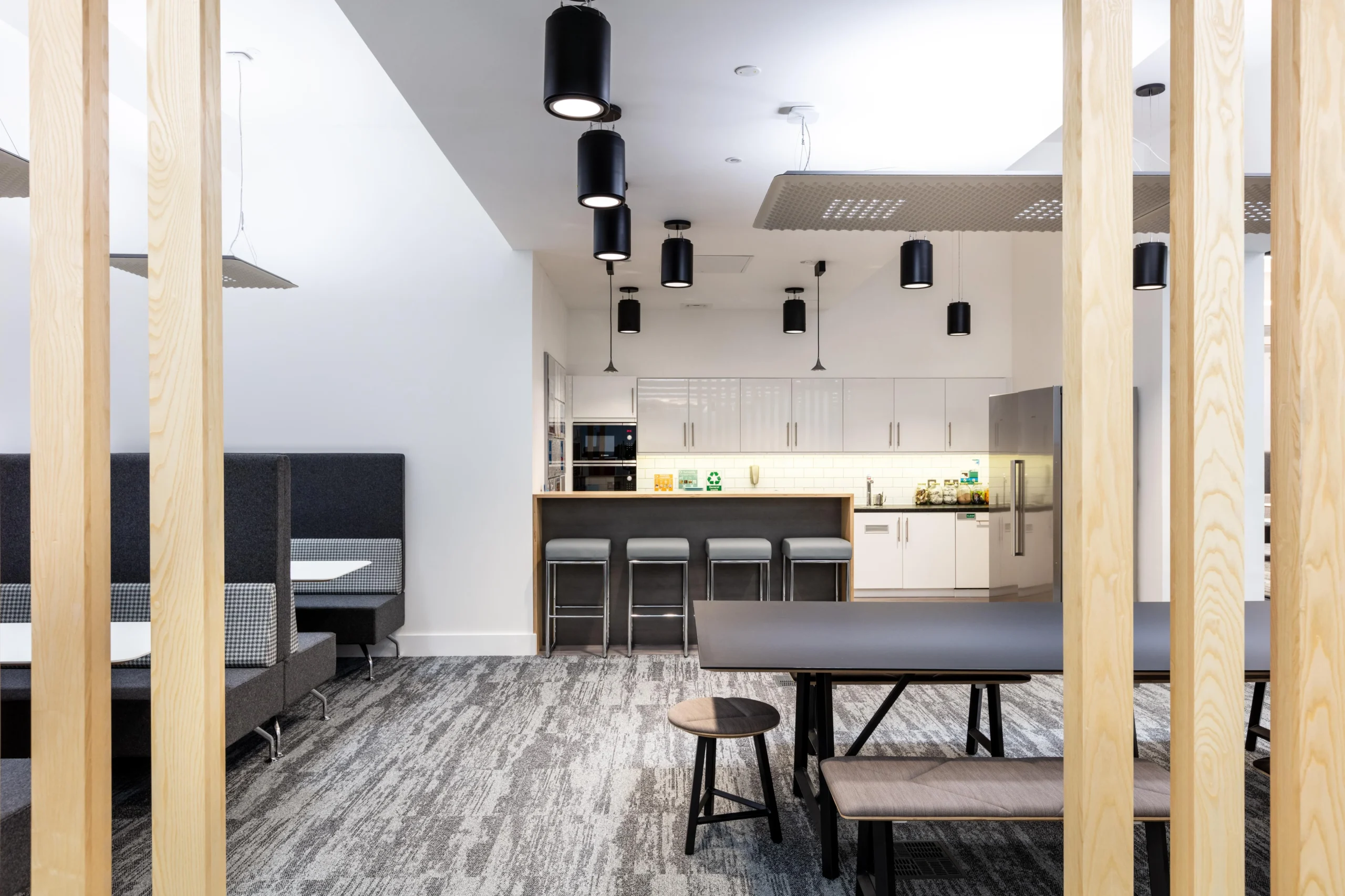 Atkins teapoint and breakout space, with kitchen amenities and booth seating, with light timber vertical slats to define the space.