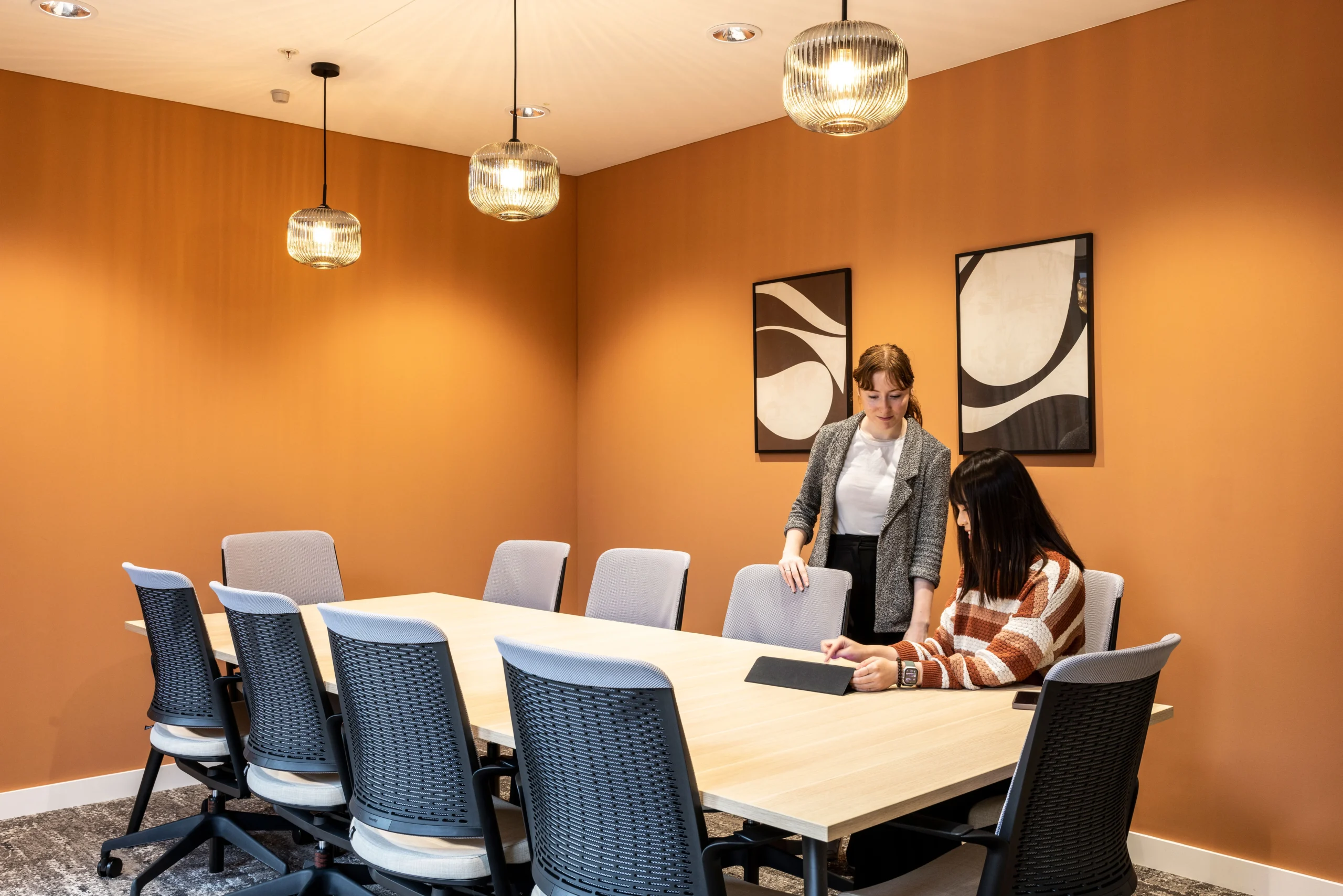 A large meeting room at Bazaarvoice's London office, designed by Modus Workspace, featuring a large table, ergonomic chairs, and advanced video conferencing tools for productive meetings.