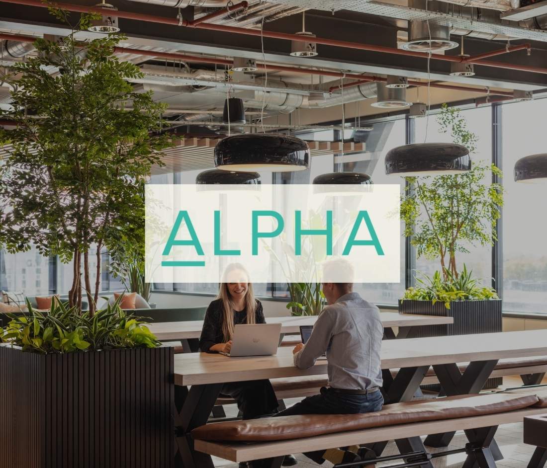 Alpha FX logo featured in a team-oriented workplace