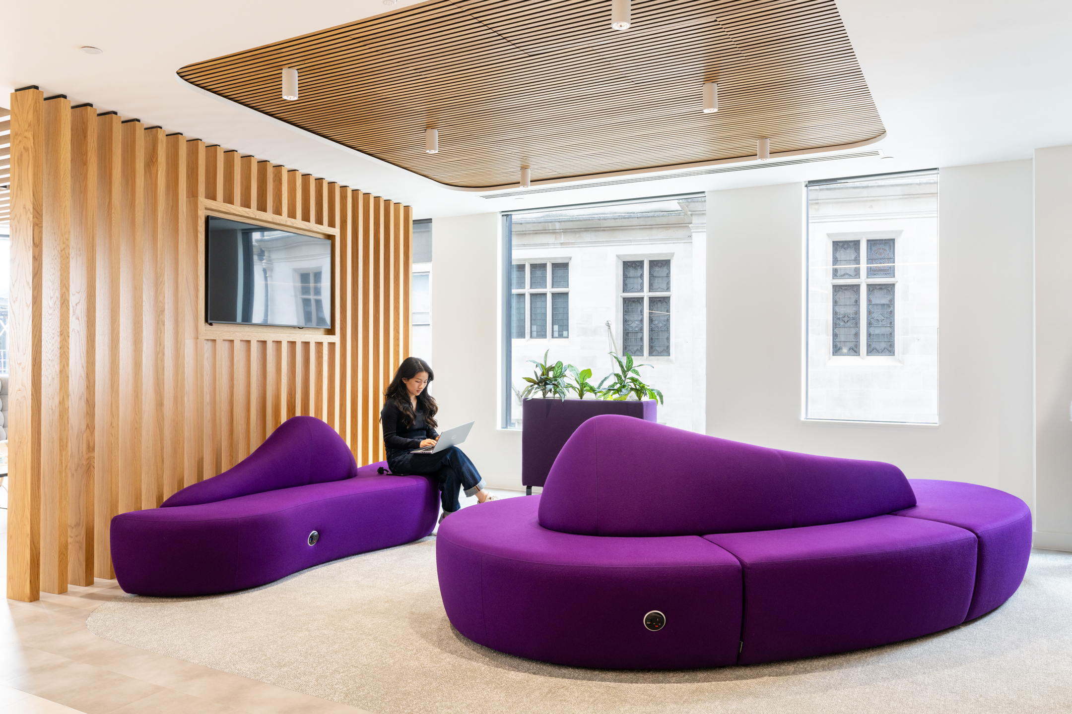 DXC Technology breakout area featuring unique purple lounge seating and wooden ceiling panels.