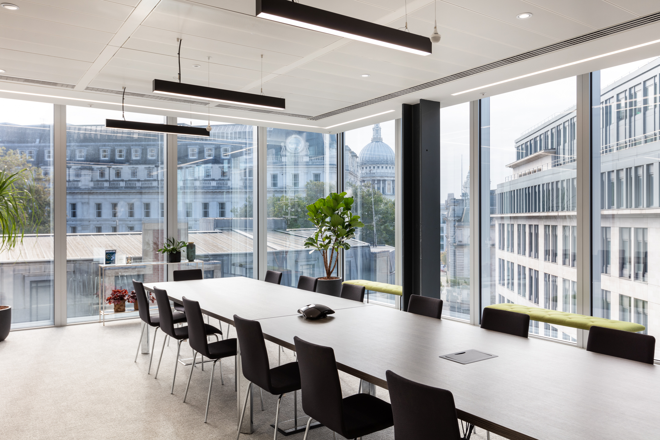 Finncap meeting room featuring a long rectangular table and black chairs, with panoramic views of central London