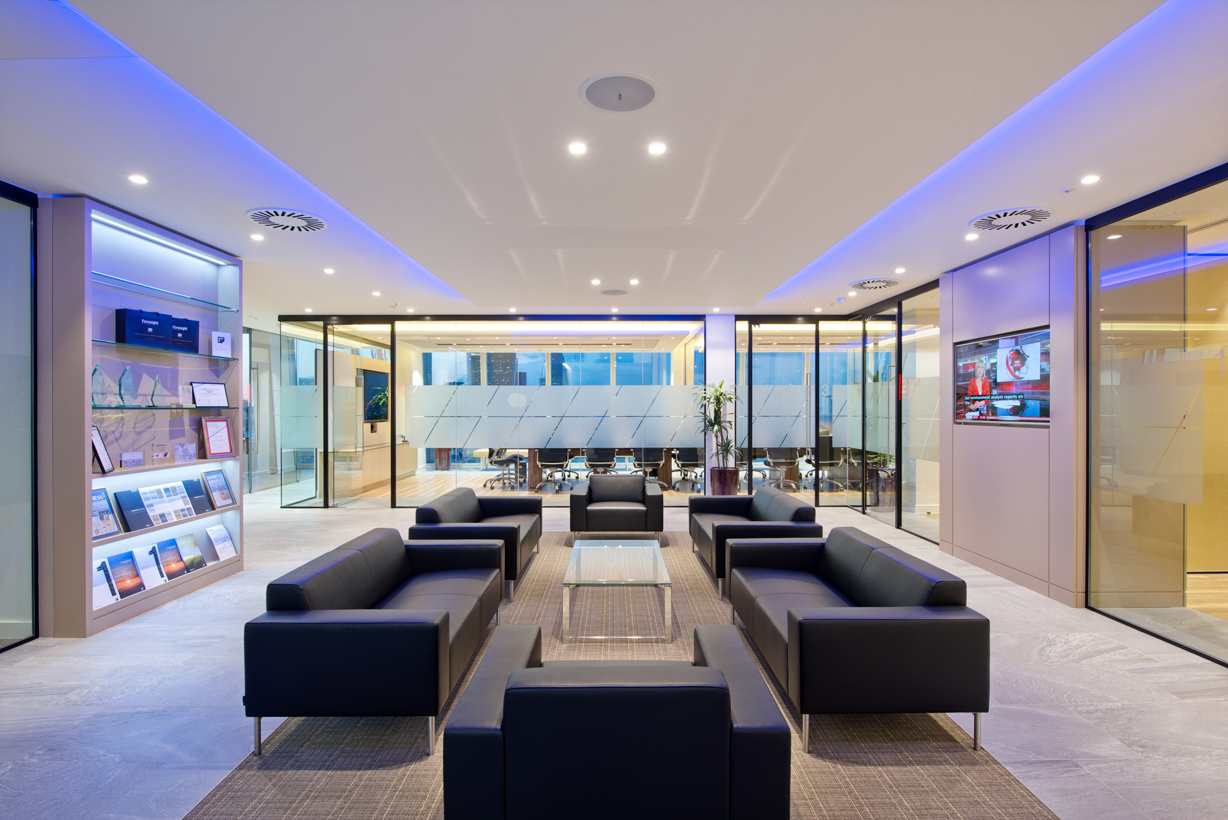 A modern reception area for Foresight Group at The Shard, featuring sleek marble surfaces and comfortable black leather seating in a well-lit space.