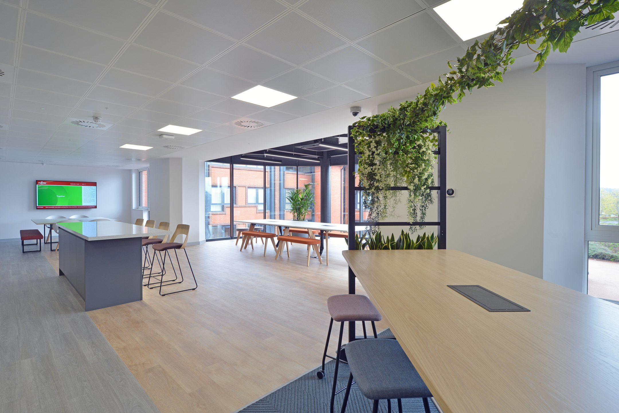 Open collaboration space at Fujitsu Services Edinburgh with natural light and modern furniture. Designed by Modus Workspace to enhance teamwork and productivity.