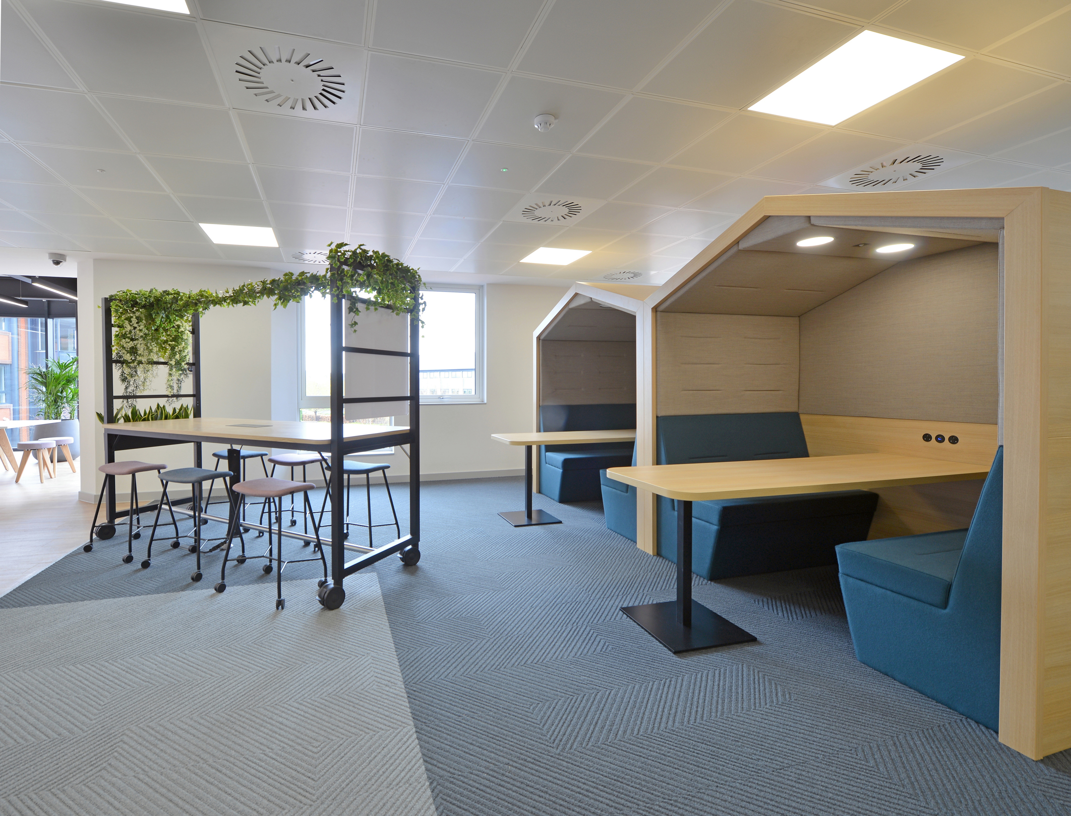 Breakout area at Fujitsu Services Edinburgh featuring booth seating and greenery. Designed by Modus Workspace to offer a relaxing and informal space for employees.