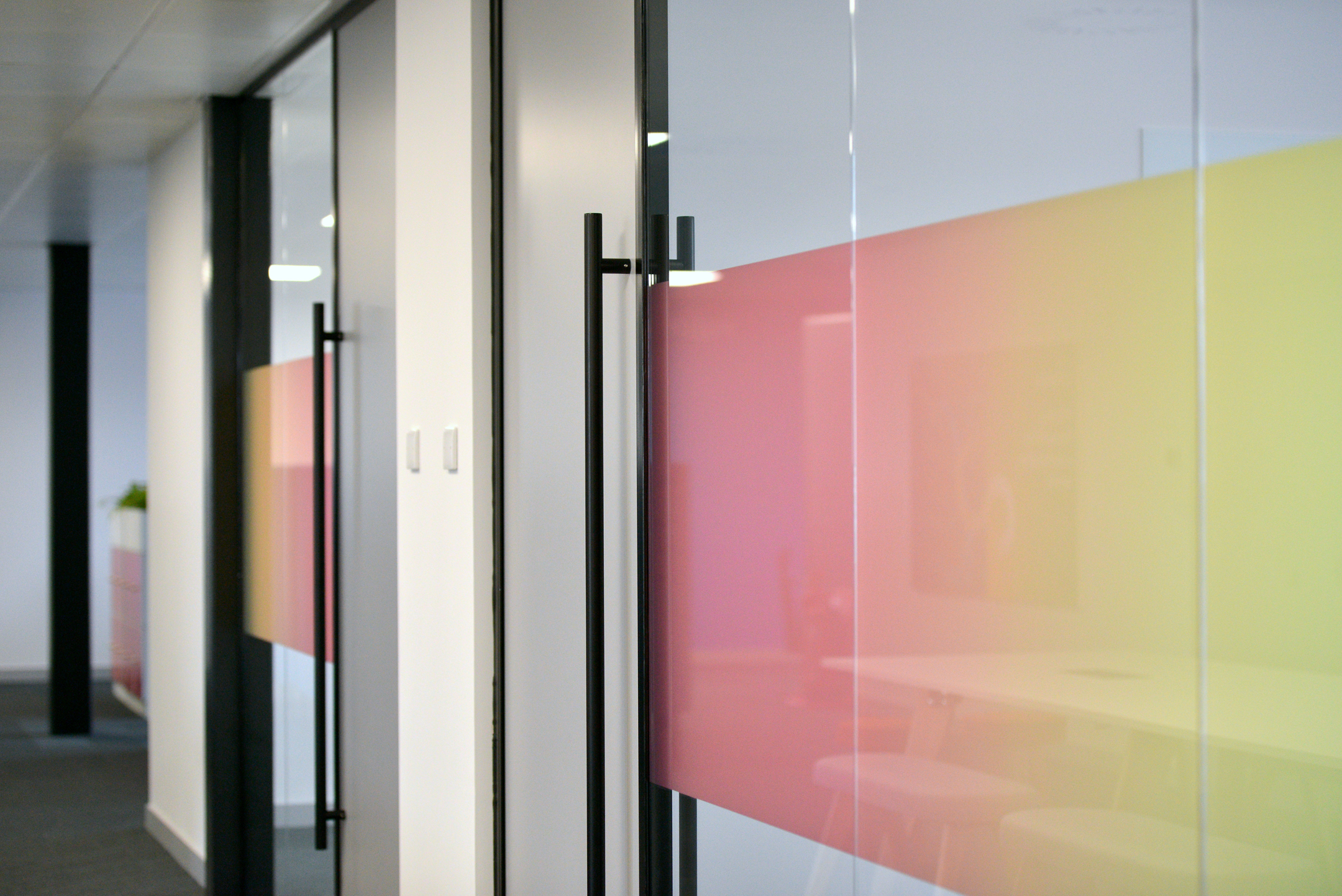 Contemporary glass partition with colourful gradient film at Fujitsu Services Edinburgh. Designed by Modus Workspace to add a modern touch and maintain privacy in meeting areas.